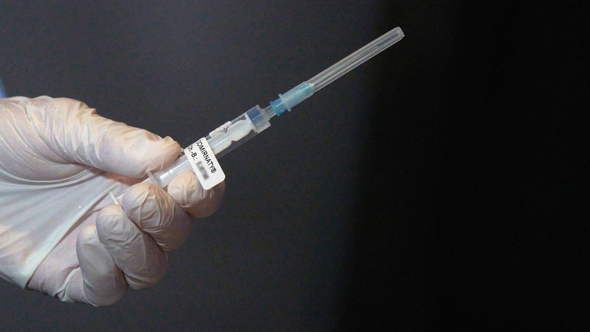 Eine Mitarbeiterin des Impfteams überprüft vor Beginn der Corona-Impfungen eine Spritze mit dem Impfstoff gegen Covid-19. | dpa