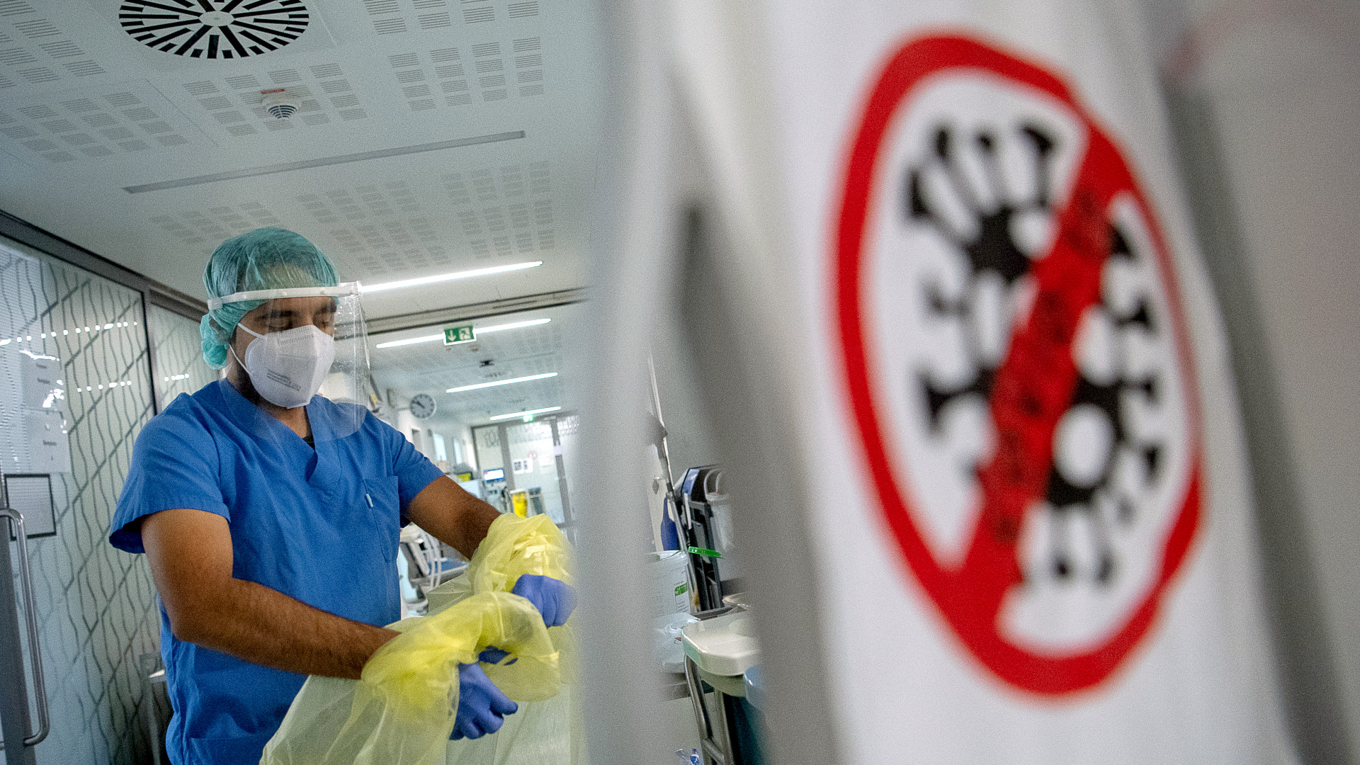 Ein Pfleger zieht beim Verlassen der Intensivstation für Corona-Patienten am Sana Klinikum Offenbach seinen Schutzkittel aus. | dpa
