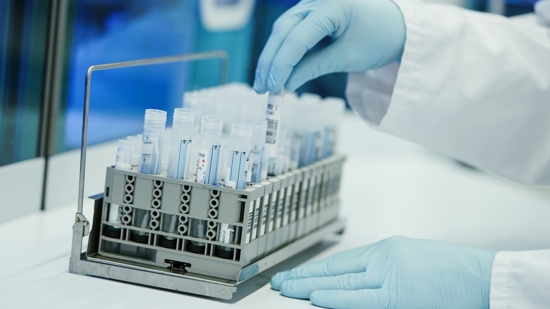 Ein Mitarbeiter hält in einem Coronatest-Labor der Limbach Gruppe PCR-Teströhrchen in den Händen. | dpa