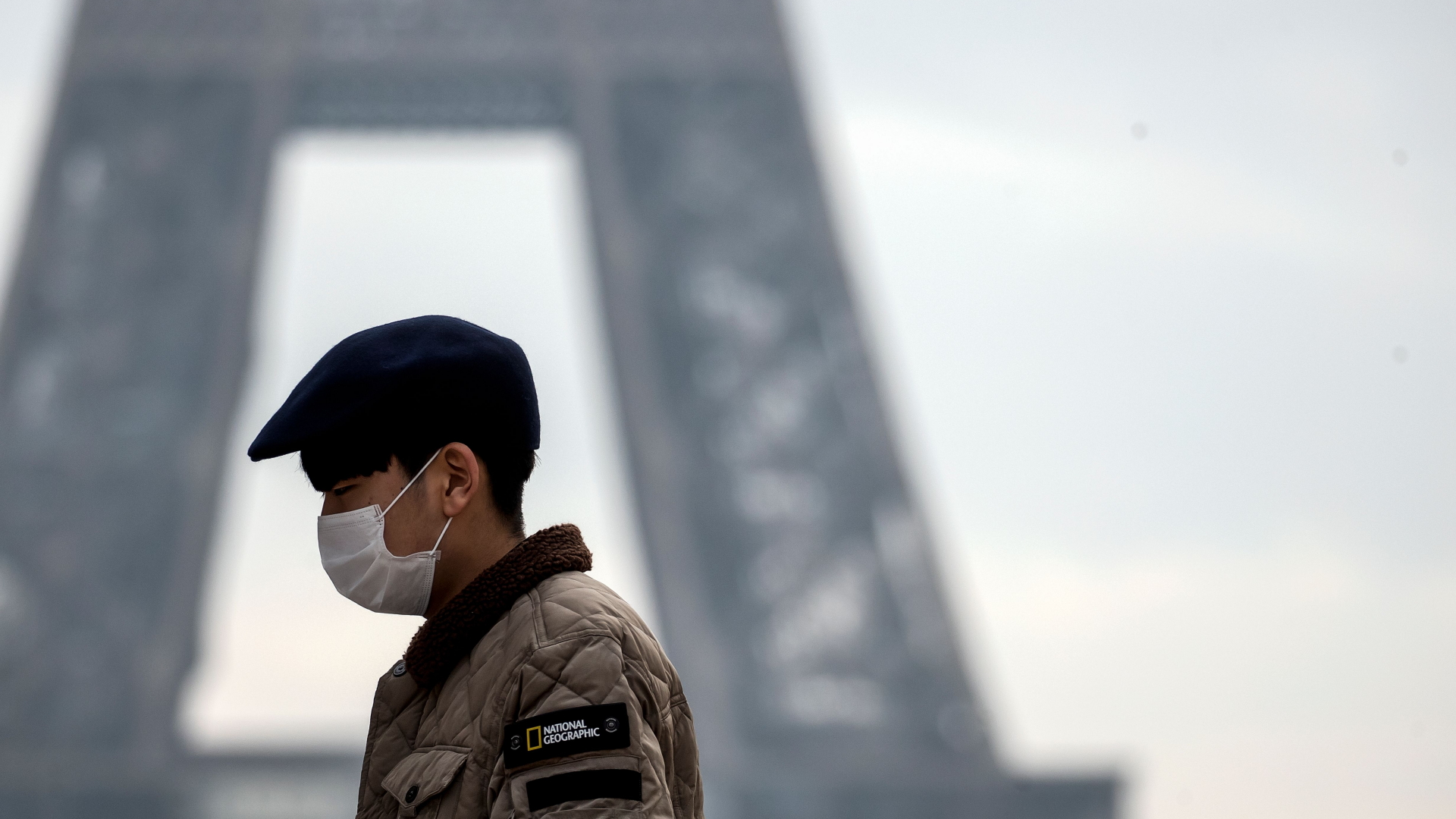 Ein Tourist mit Atemmaske vor dem Eiffelturm in Paris. | IAN LANGSDON/EPA-EFE/REX