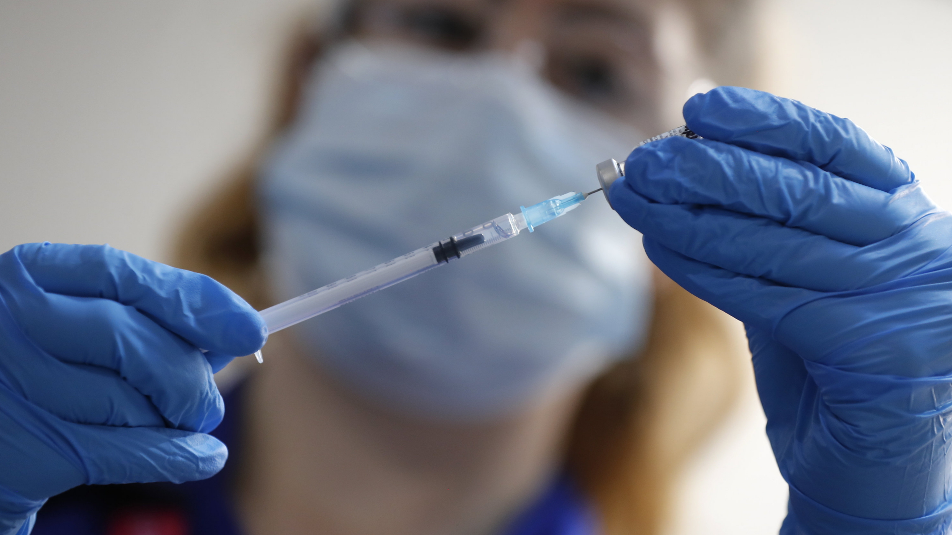 Eine Krankenschwester zieht eine Spritze mit dem Corona-Impfstoff von Biontech und Pfizer auf. | AP