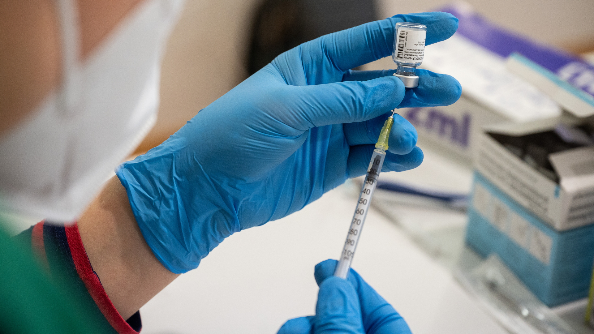 Eine Mitarbeiterin eines Impfteams zieht eine Spritze mit dem Coronavirus-Vakzin auf. | dpa