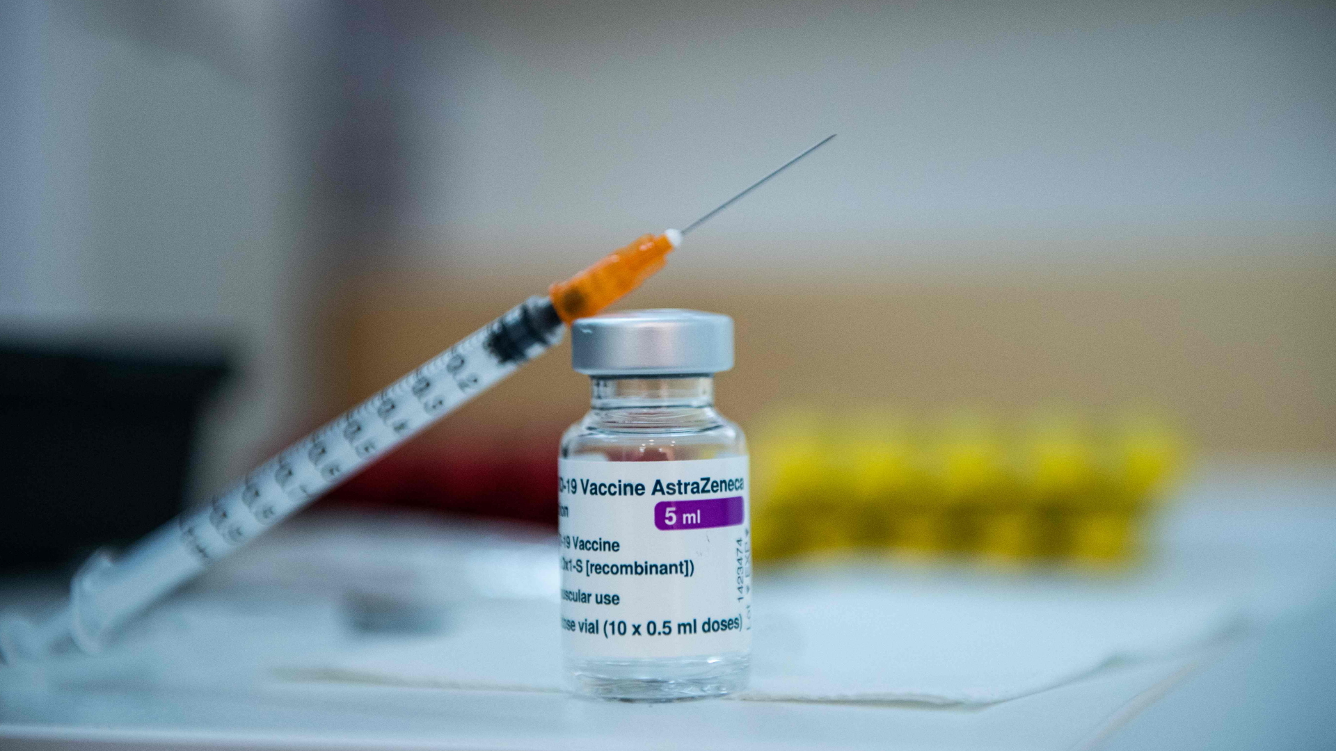 Eine Spritze liegt an eine Ampulle mit dem Corona-Impfstoff von AstraZeneca gelehnt. | AFP