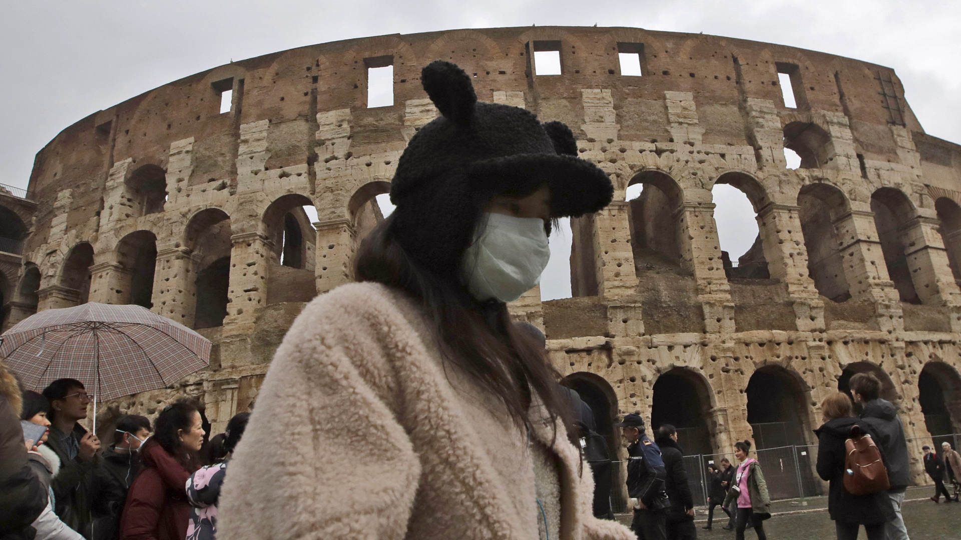 Eine Touristin aus China trägt während eines Besuchs des Kolosseums einen Mundschutz. | dpa