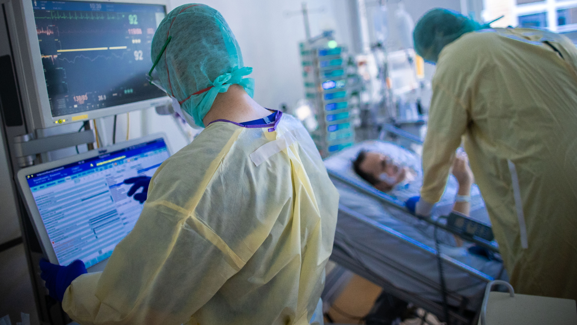 Zwei Ärzte in Schutzkleidung kümmern sich im Klinikum in Greifswald im einen Corona-Patienten.
