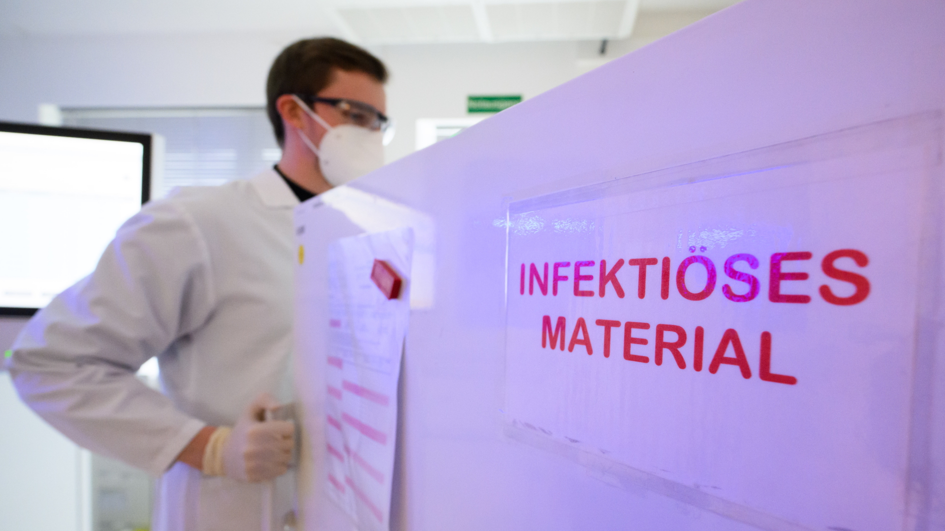 Labormitarbeiter Christoph Majowski steht im Labor Nordlab vor einem Kühlschrank mit Patientenproben, auf dem der Warnhinweis "Infektiöses Material" steht.  | dpa