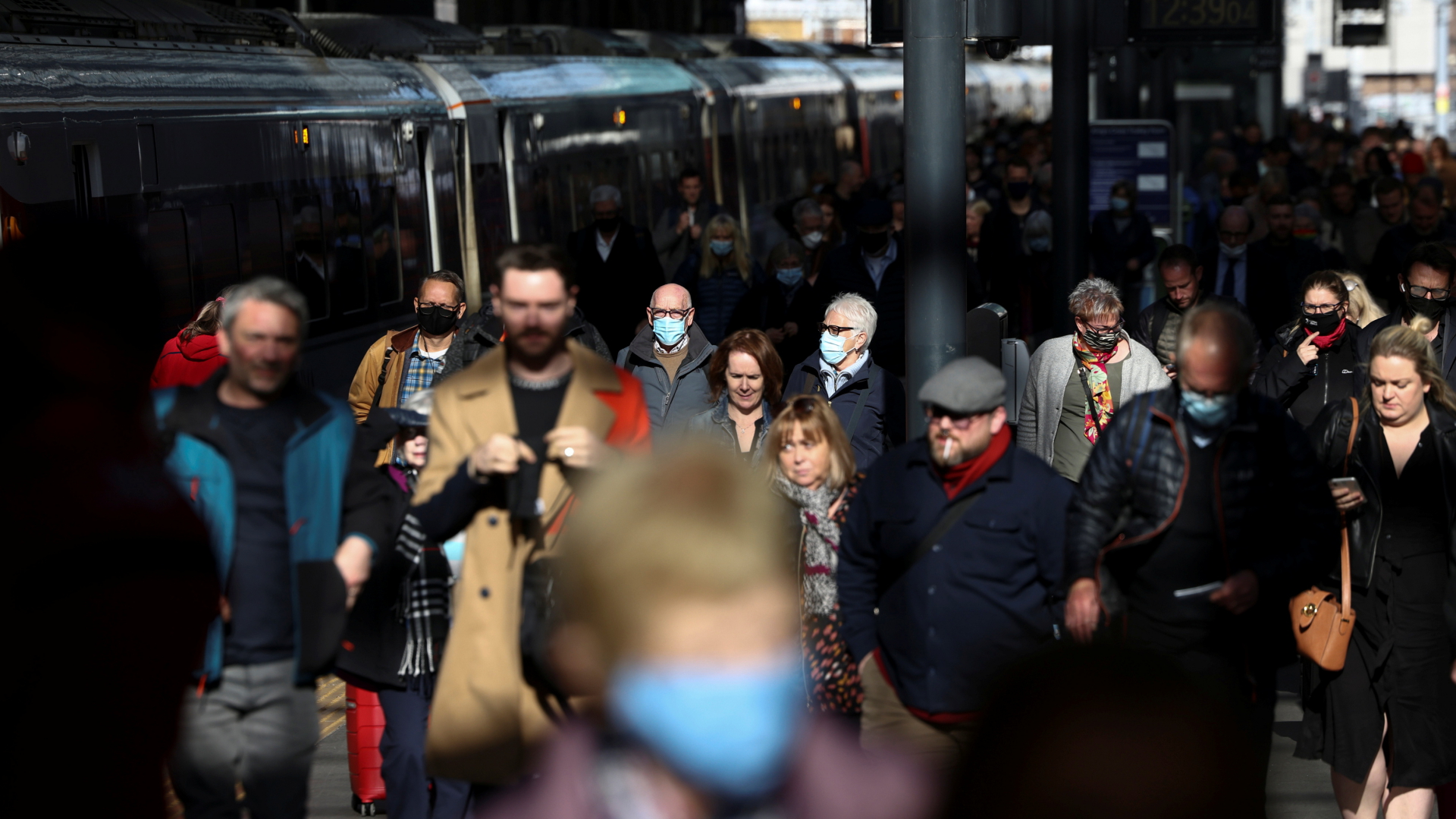 Menschen gehen am Londoner Bahnhof King's Cross auf einem vollen Bahnsteig entlang. | REUTERS