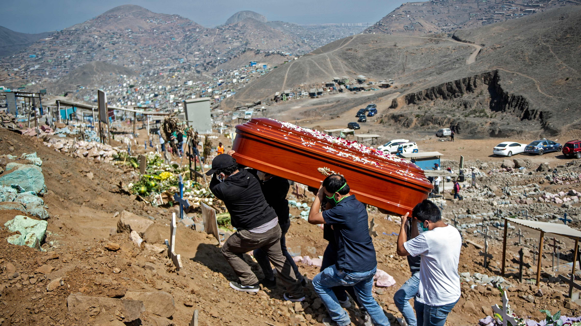Der Sarg eines mutmaßlich an Covid-19 verstorbenen Menschen wird zu einem Friedhof gebracht, der außerhalb Limas auf den Bergen liegt. | AFP