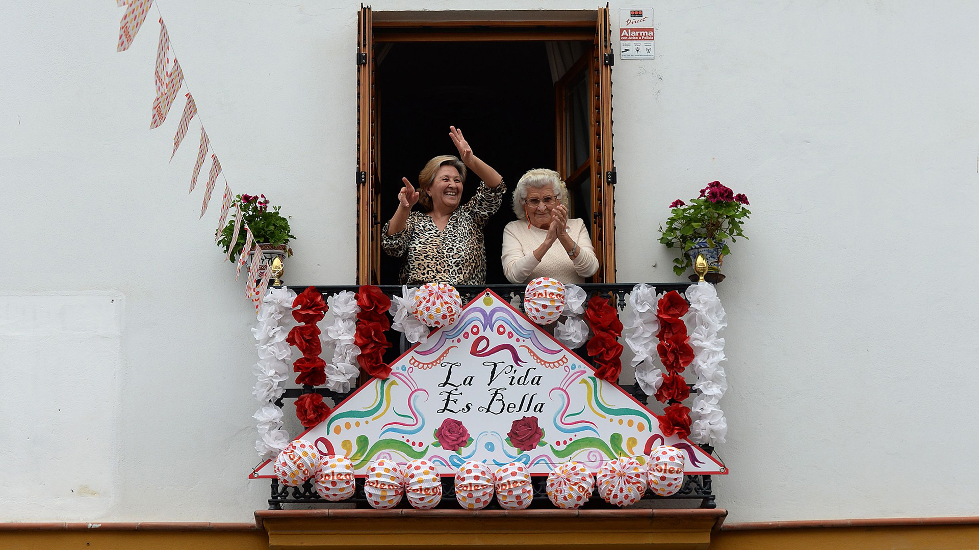 Zwei ältere Bewohnerinnen Sevillas feiern auf ihrem Balkon | AFP