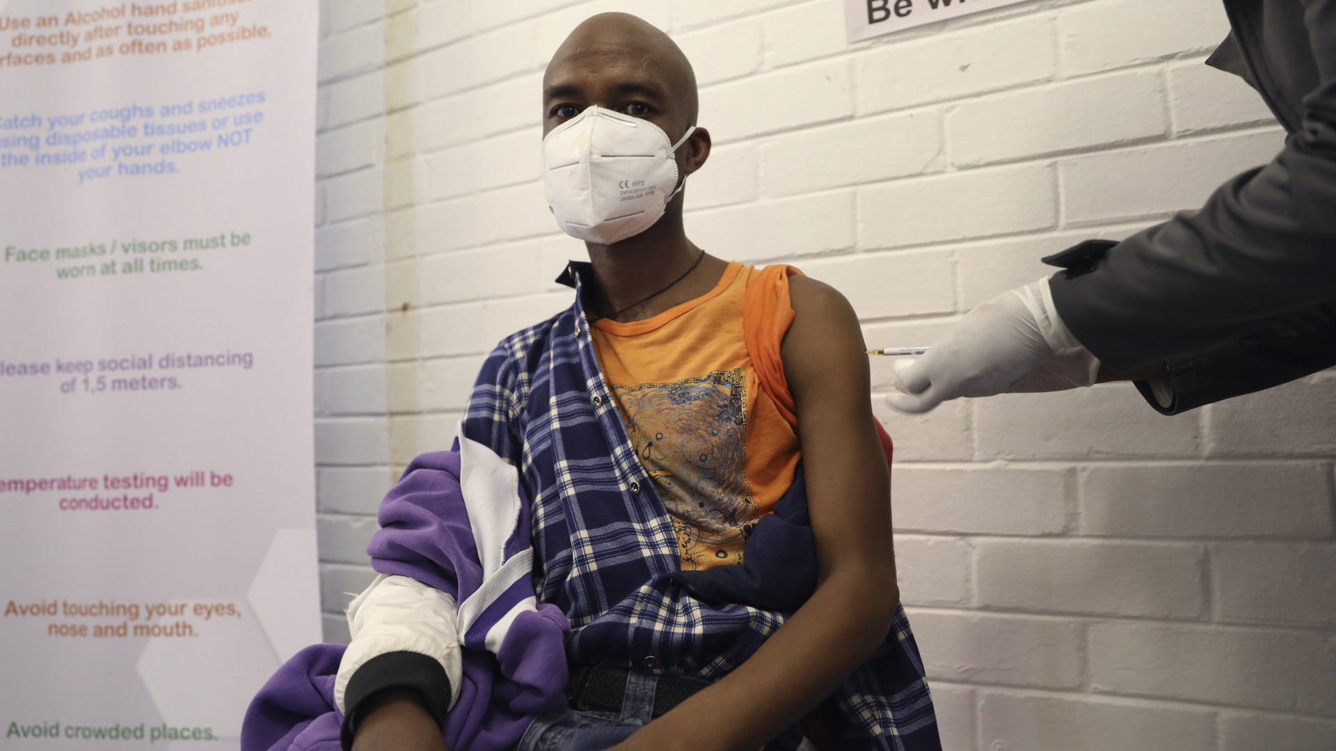 Ein Mann lässt sich in Johannesburg  freiwillig einen Corona-Impfstoff injizieren. | AP