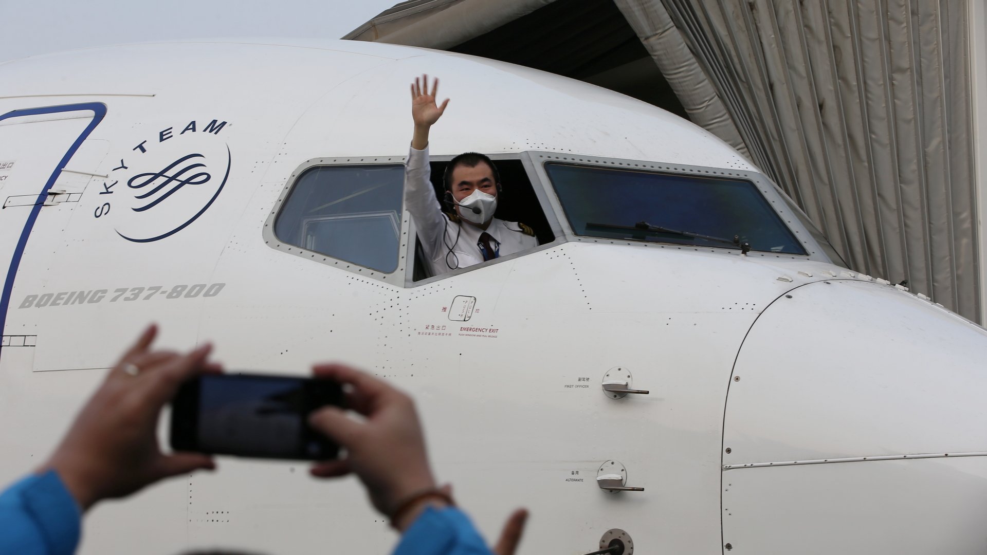 Ein Pilot winkt aus dem Cockpit - es ist der erste Inlandsflug, der in Wuhan seit der Abriegelung der region wegen des Coronavirus startet.