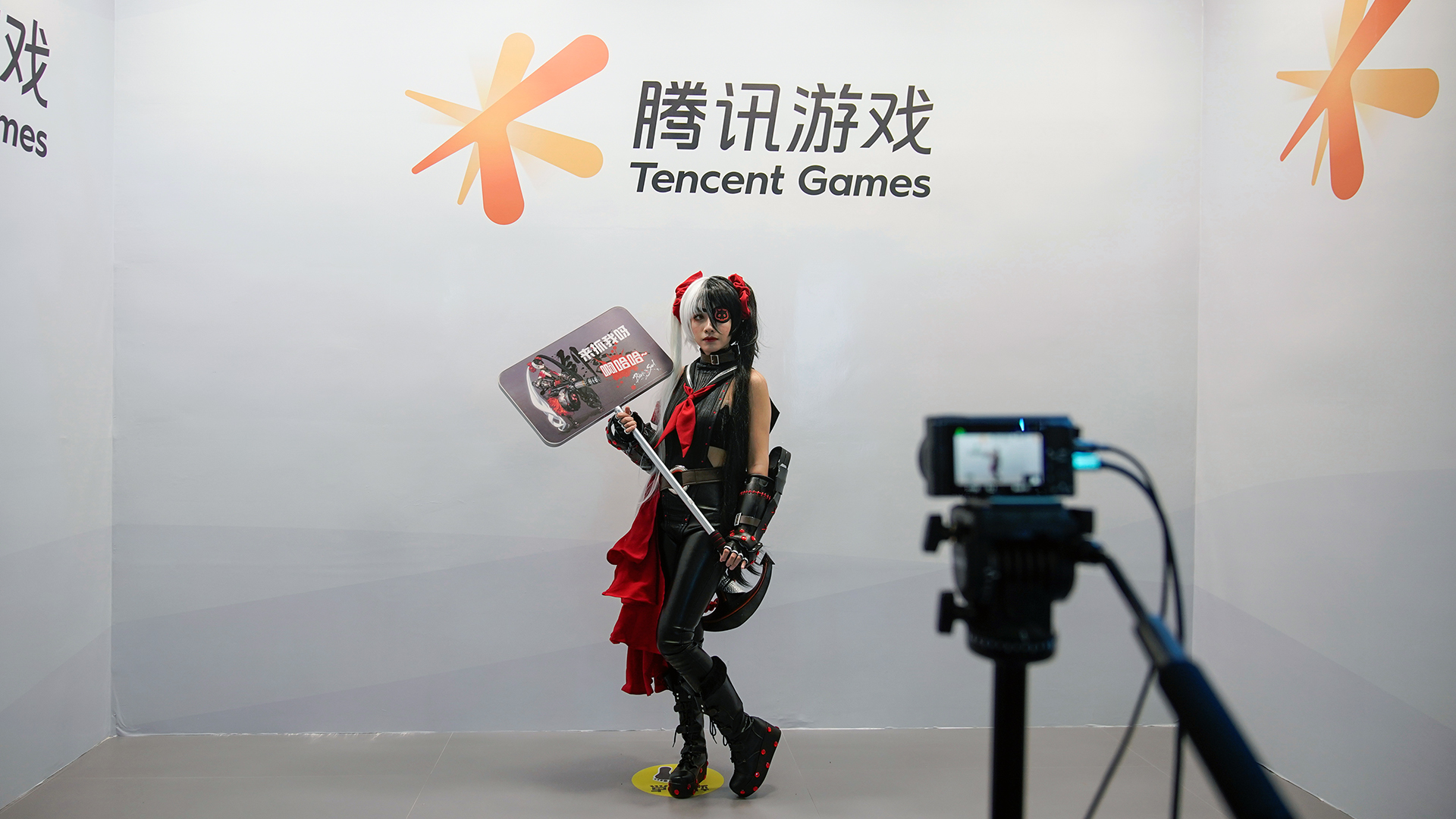 Ein Cosplay-Fan posiert für ein Foto vor dem Logo von Tencent Games | REUTERS