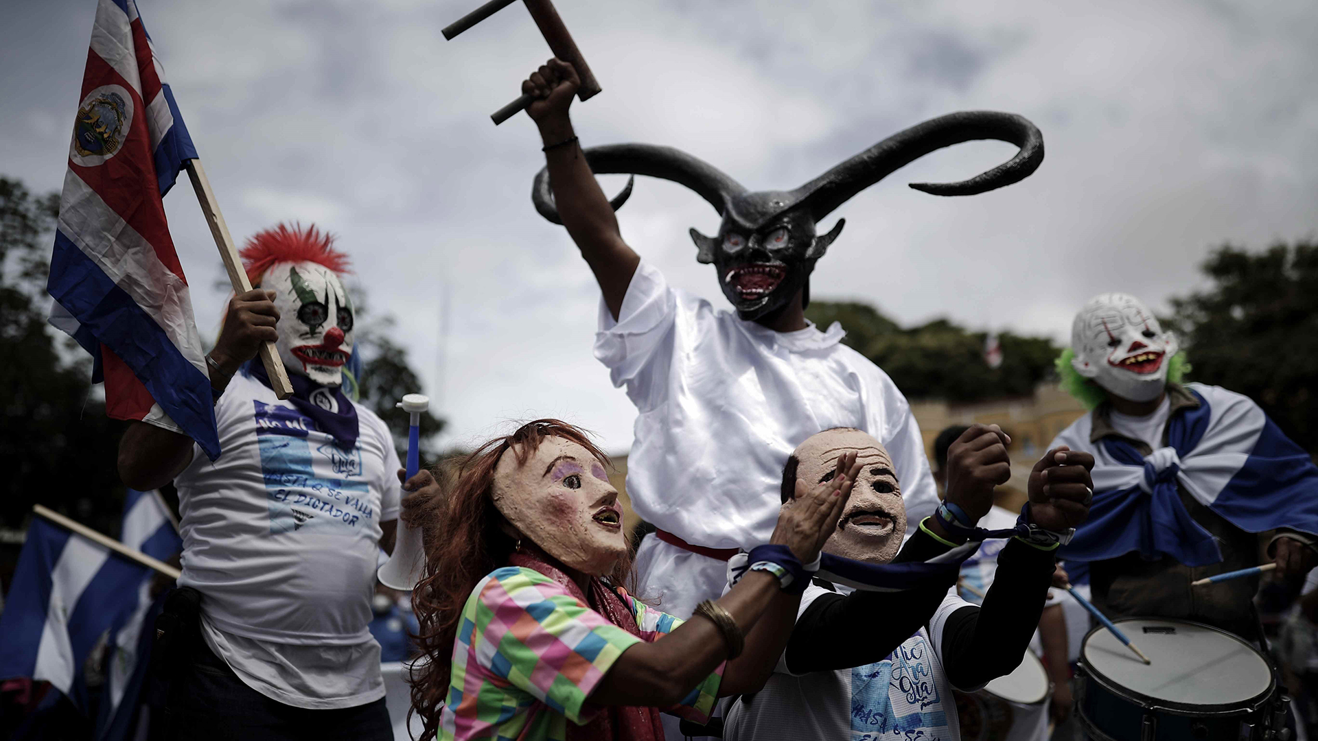 Zwei Personen mit Masken, die den Präsidenten von Nicaragua, Daniel Ortega, und seine Frau, die Vizepräsidentin Rosario Murillo, in Handschellen darstellen. | EPA