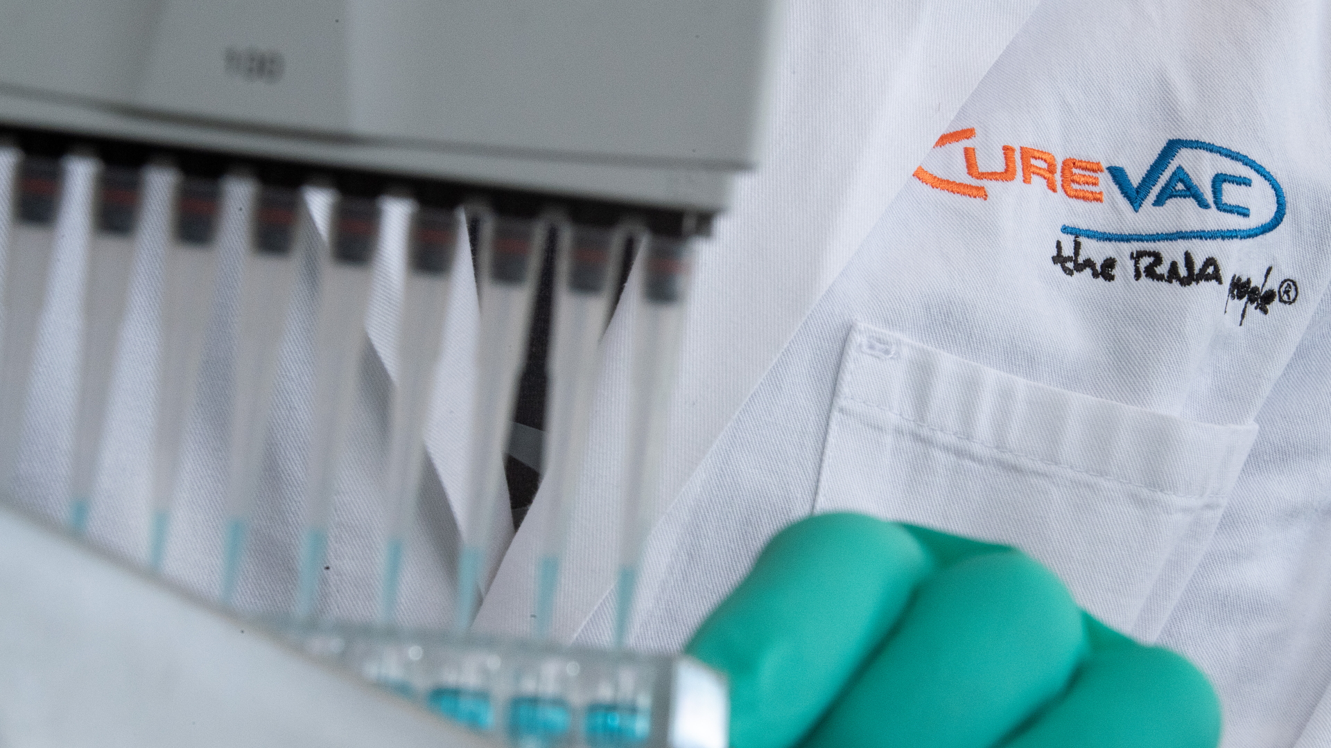 Ein Mann pipettiert in einem Labor des biopharmazeutischen Unternehmens Curevac eine blaue Flüssigkeit.
