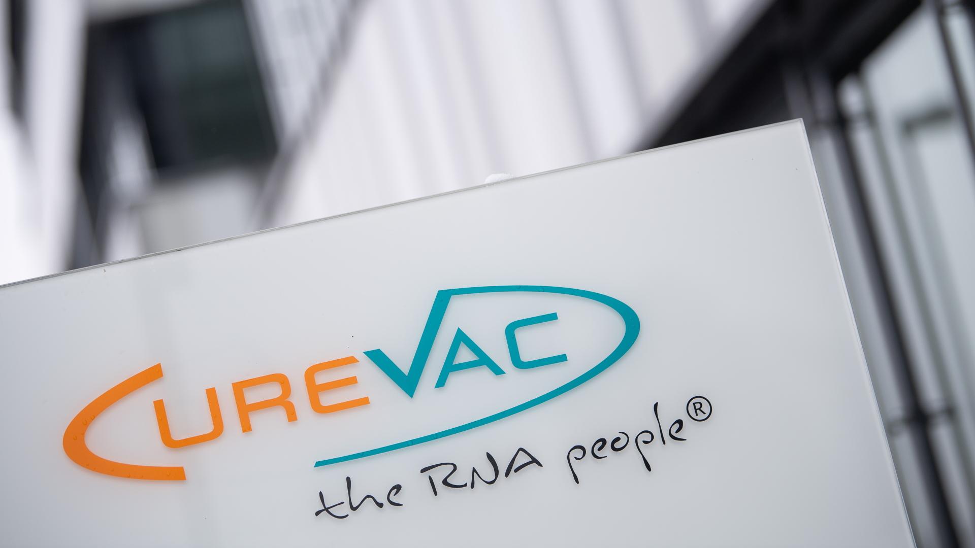Das Logo des Unternehmens CureVac mit dem Slogan "the RNA people" steht an der Unternehmenszentrale.