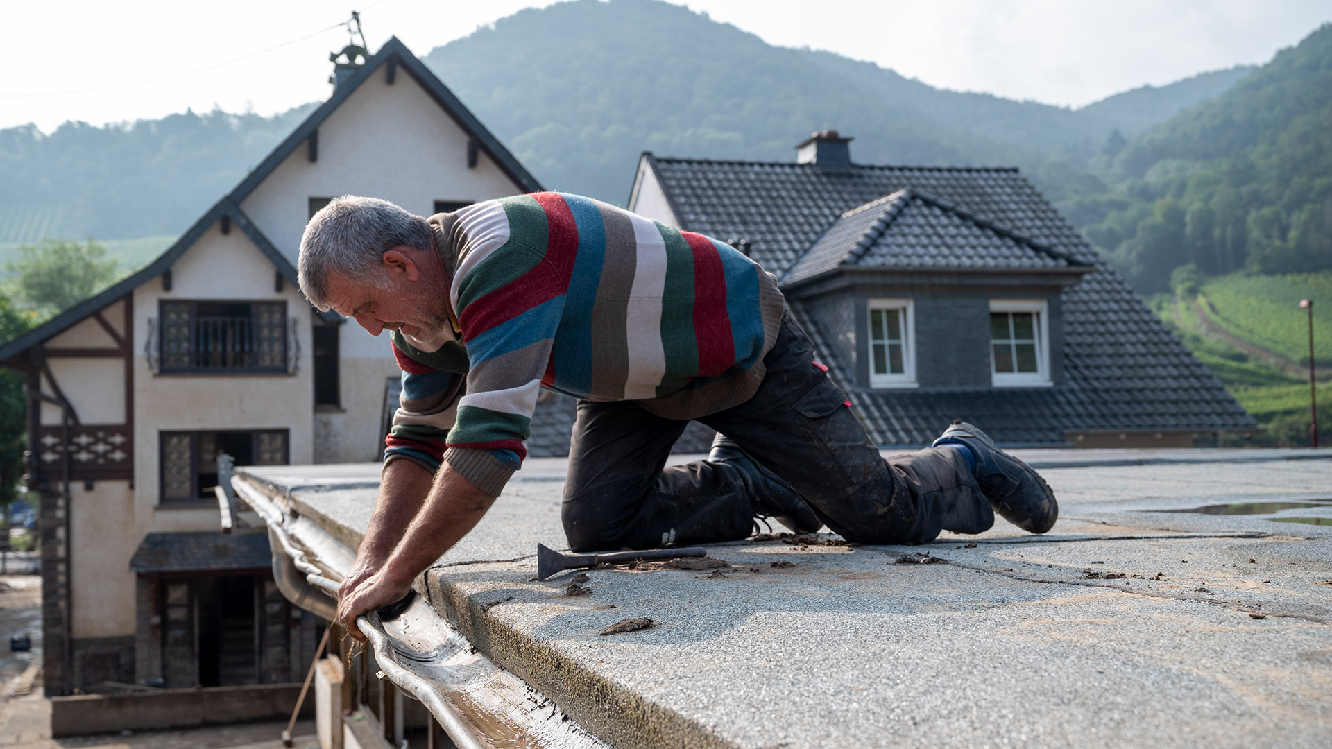 Dachdecker Udo Arndt aus dem Sauerland arbeitet an einem der Dächer, die von der Flutkatastrophe beschädigt worden sind. | dpa