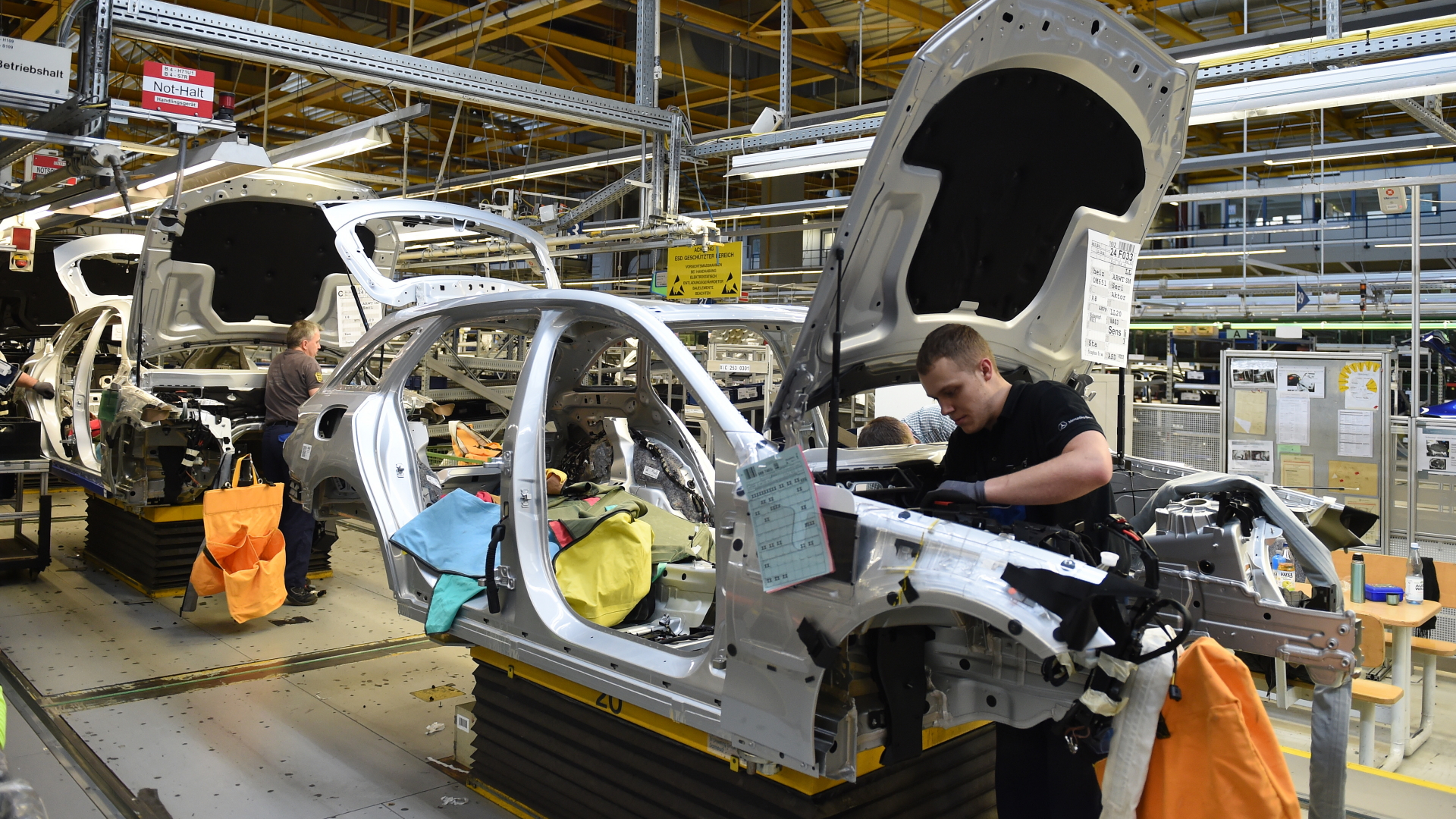 Mitarbeiter von Mercedes-Benz arbeiten im Werk in Bremen an einer C-Klasse. | dpa