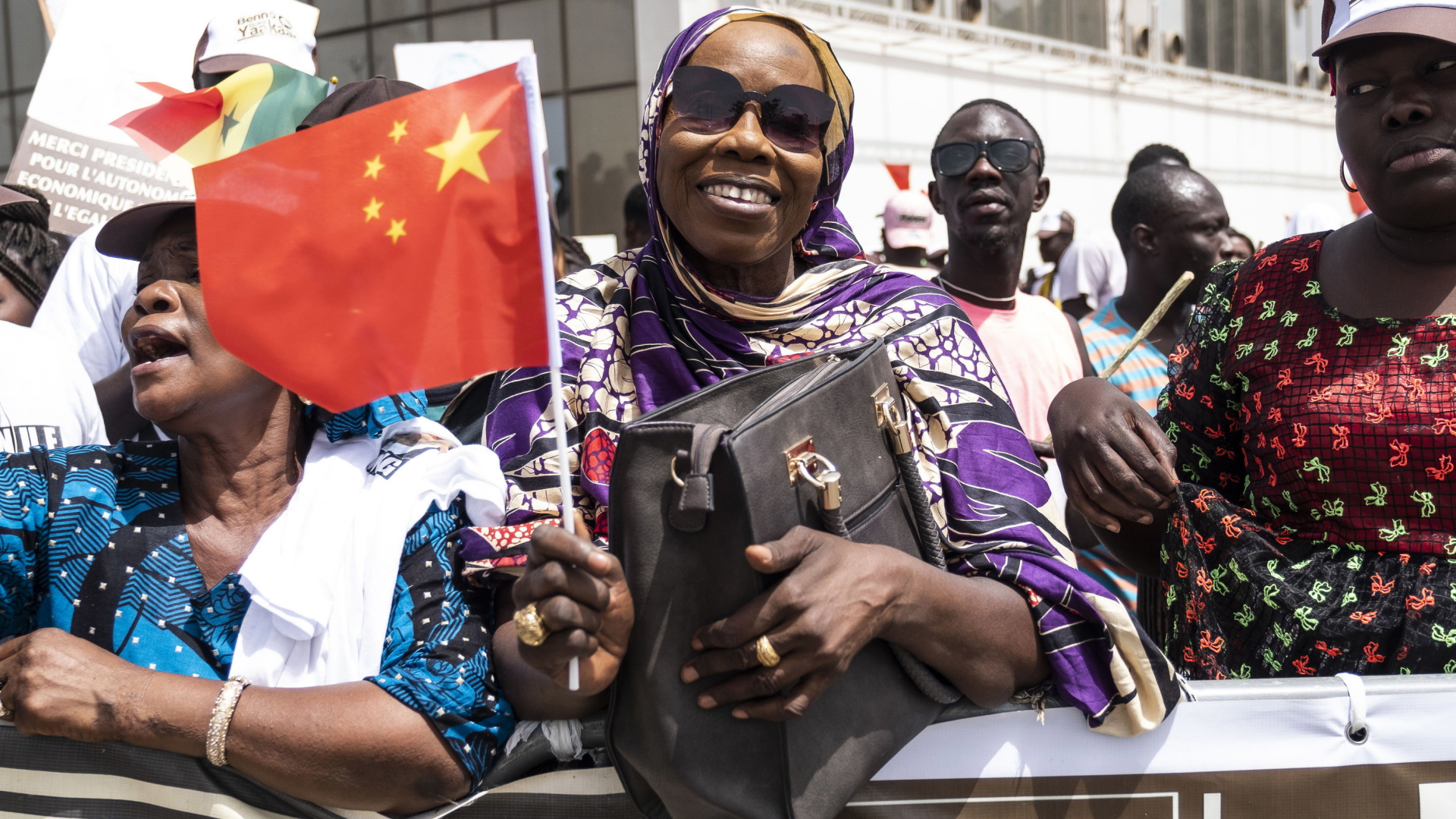 Eine Senegalesin winkt in Dakar mit einer chinesischen Fahne. (Archivbild vom 21.07.2018) | dpa