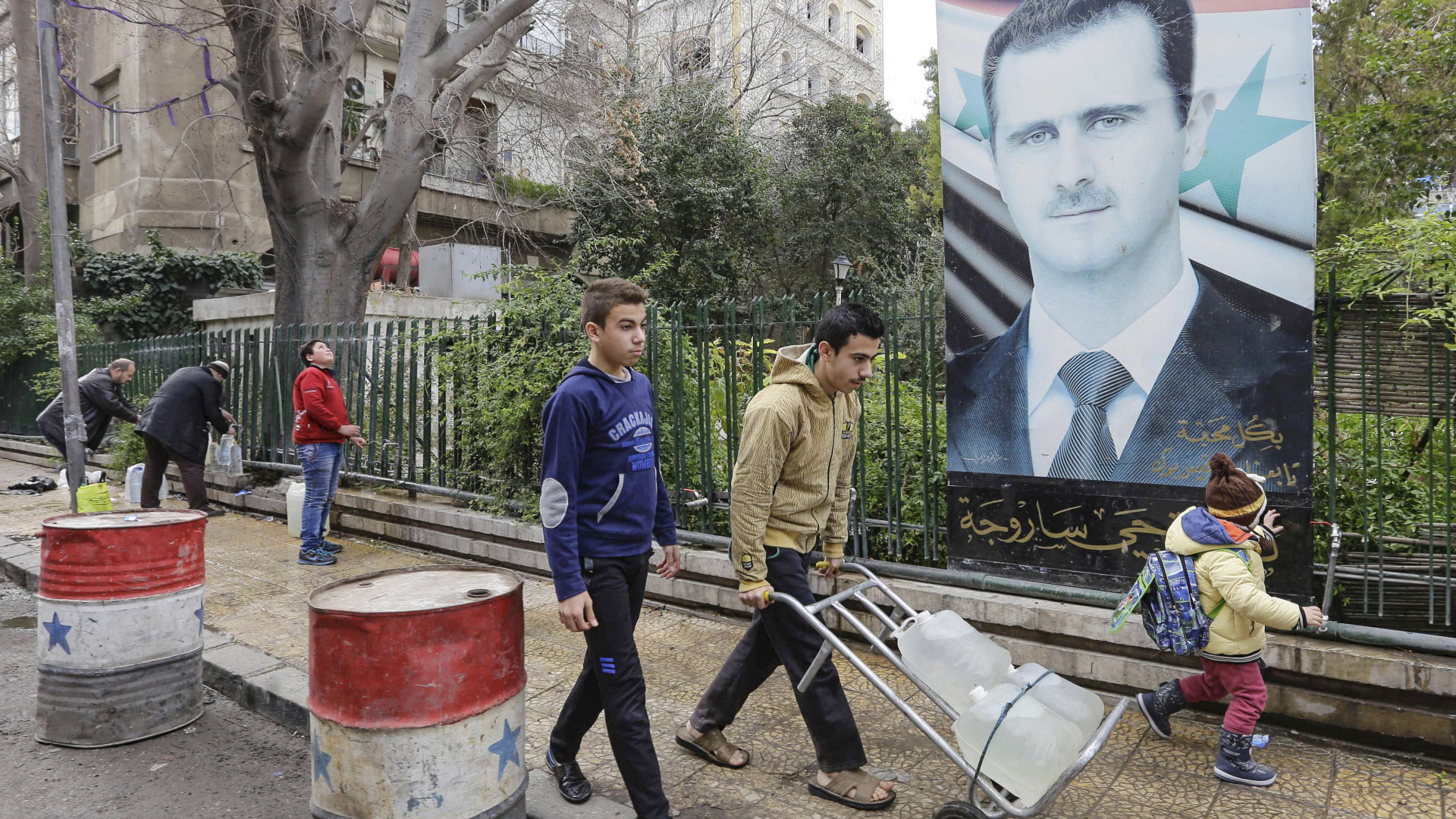 Menschen in der syrischen Hauptstadt Damaskus warten mit Kanistern auf Wasser | Bildquelle: AFP