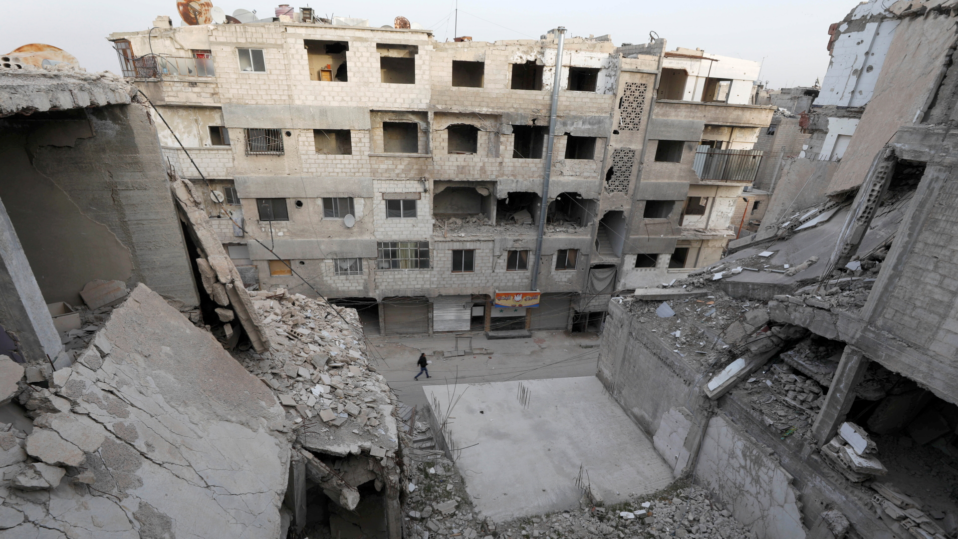 Ein Mann geht an Häuserruinen in Damaskus vorbei | REUTERS
