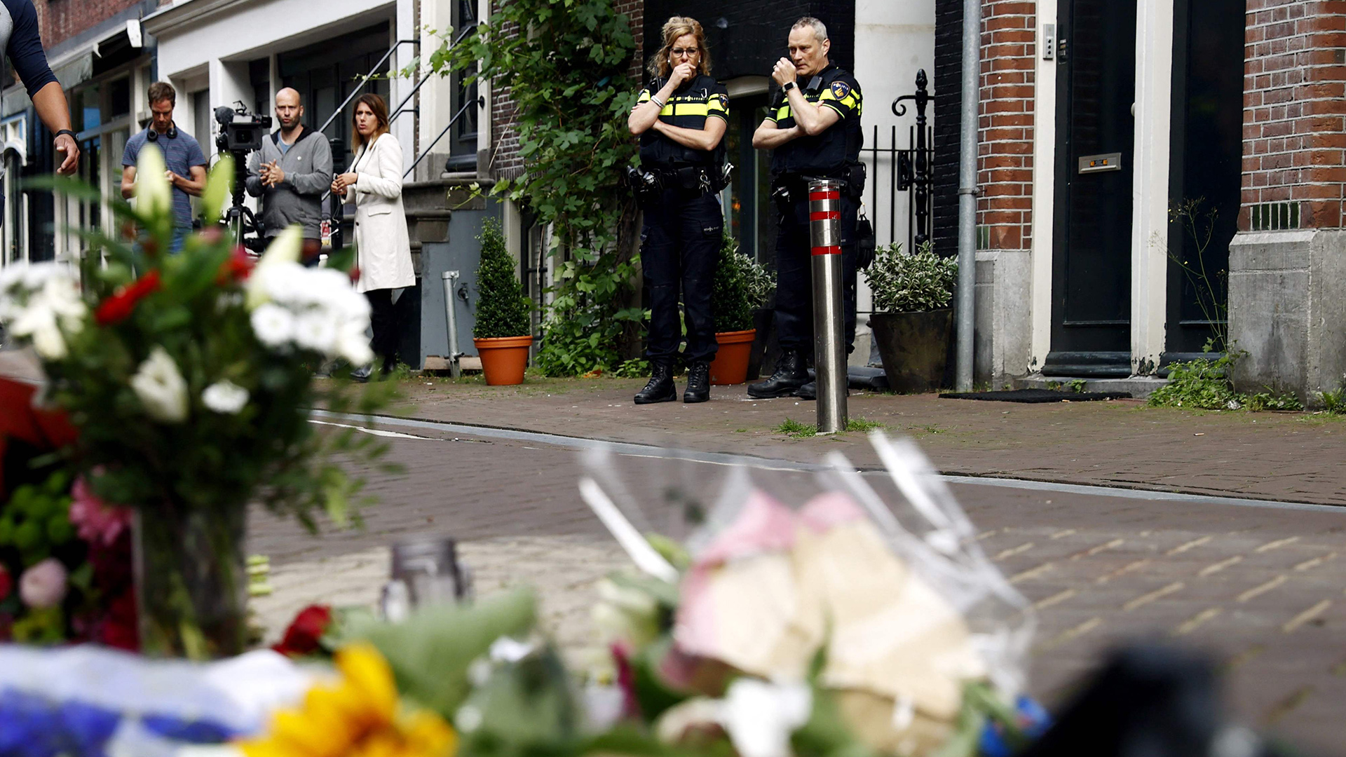 Menschen und Blumen am Tatort in der Lange Leidsedwarsstraat im Zentrum Amsterdam. | AFP