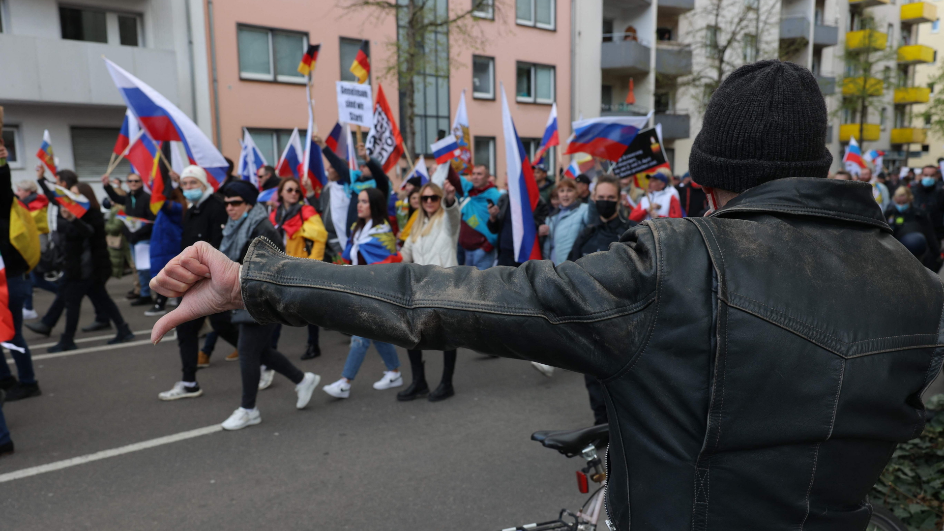 Ein Mann gestikuliert mit dem Daumen seine Ablehnung gegen eine pro-russische Demo in Frankfurt/Main  | AFP