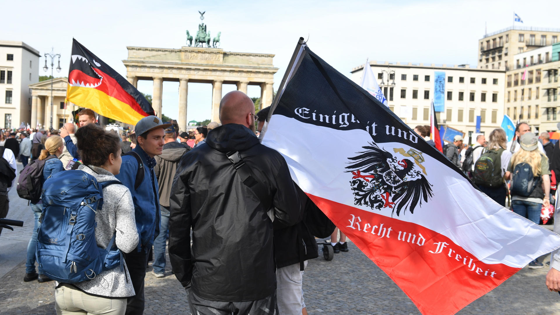 Berlin: Ein Teilnehmer hält vor einer Demonstration gegen die Corona-Maßnahmen eine Reichsflagge vor dem Brandenburger Tor | dpa