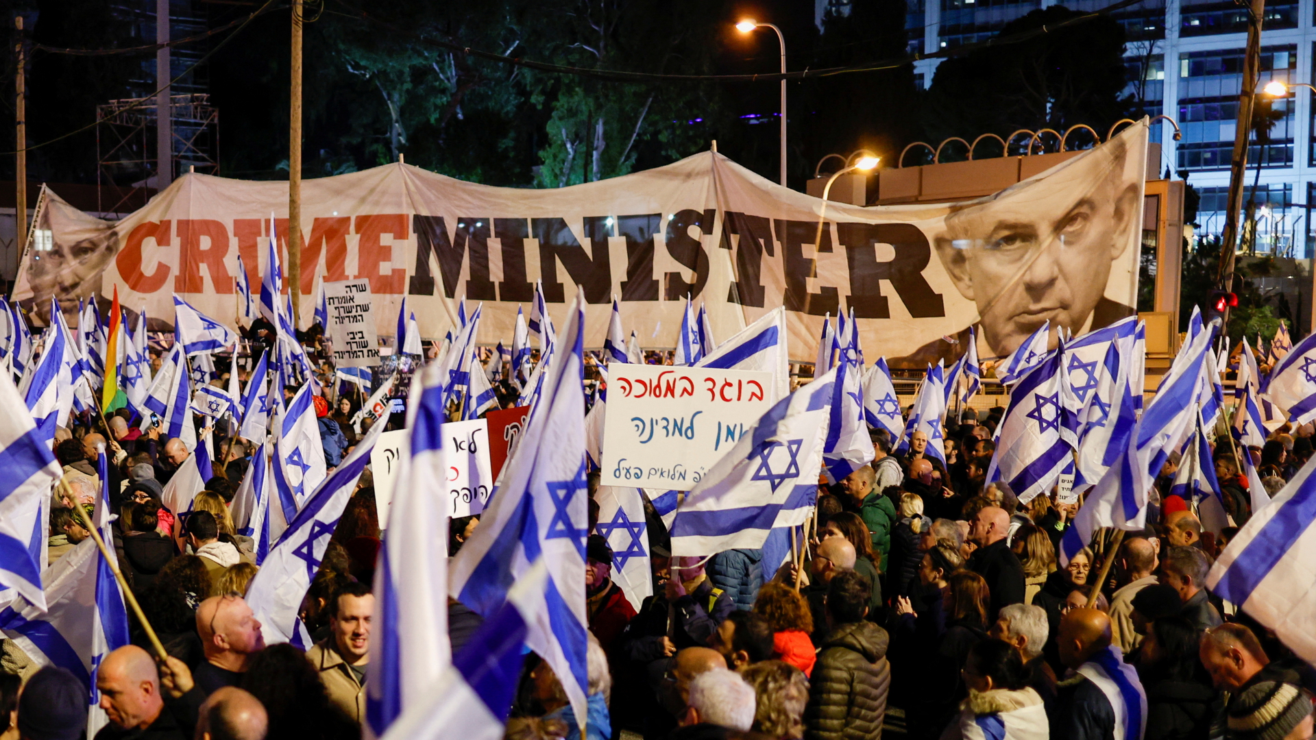 Demonstranten halten israelische Flaggen in Tel Aviv in die Höhe | REUTERS
