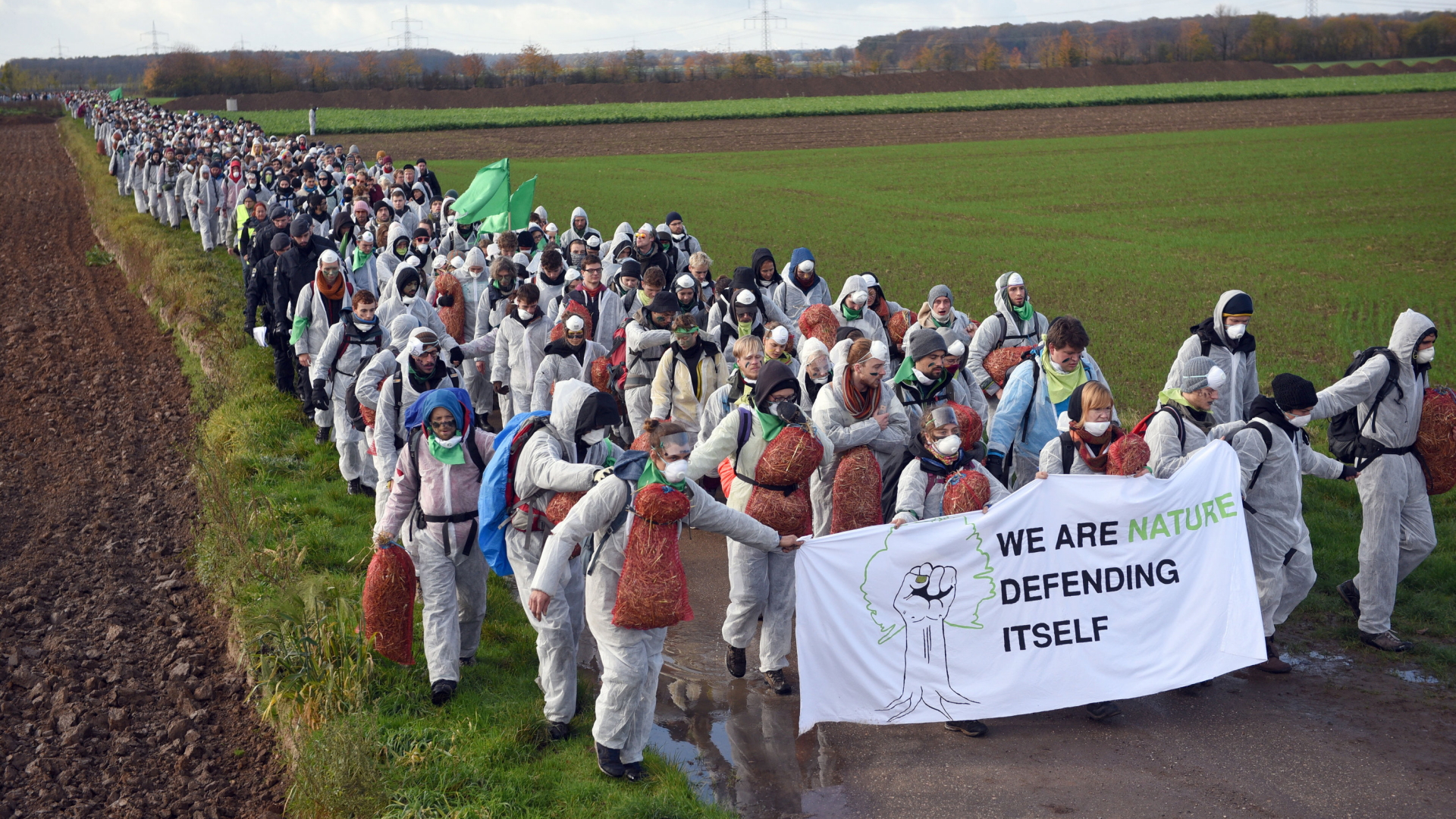 Teilnehmer einer Demonstration für den Kohleausstieg laufen in Richtung des Tagebaus Hambach (Nordrhein-Westfalen) | dpa
