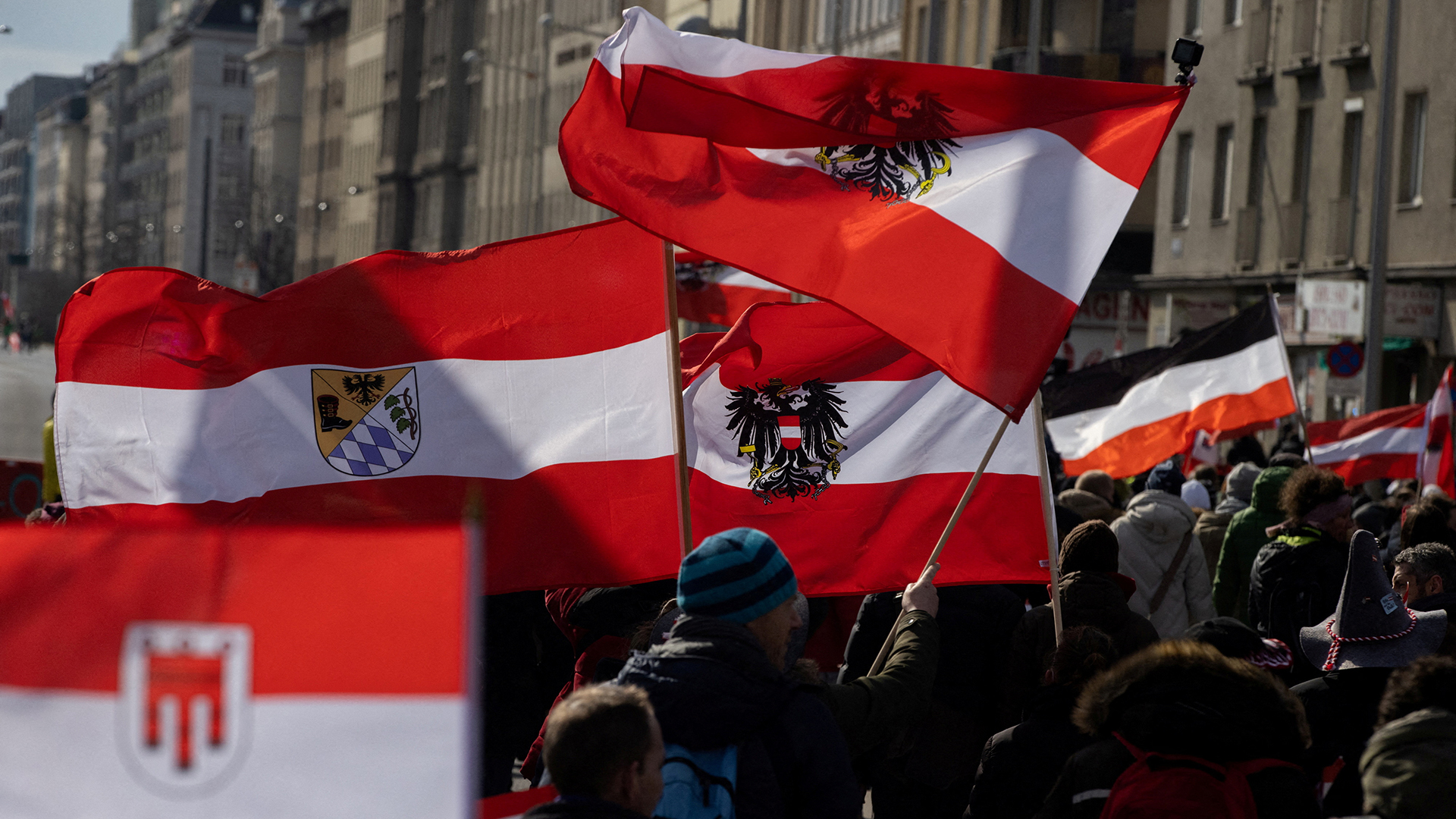 Menschen tragen österreichische Flaggen, während sie bei einer Demonstration gegen die Maßnahmen gegen die Coronavirus-Krankheit (COVID-19) in Wien (Österreich) demonstrieren. (Archivbild: 20. März 2021) | REUTERS