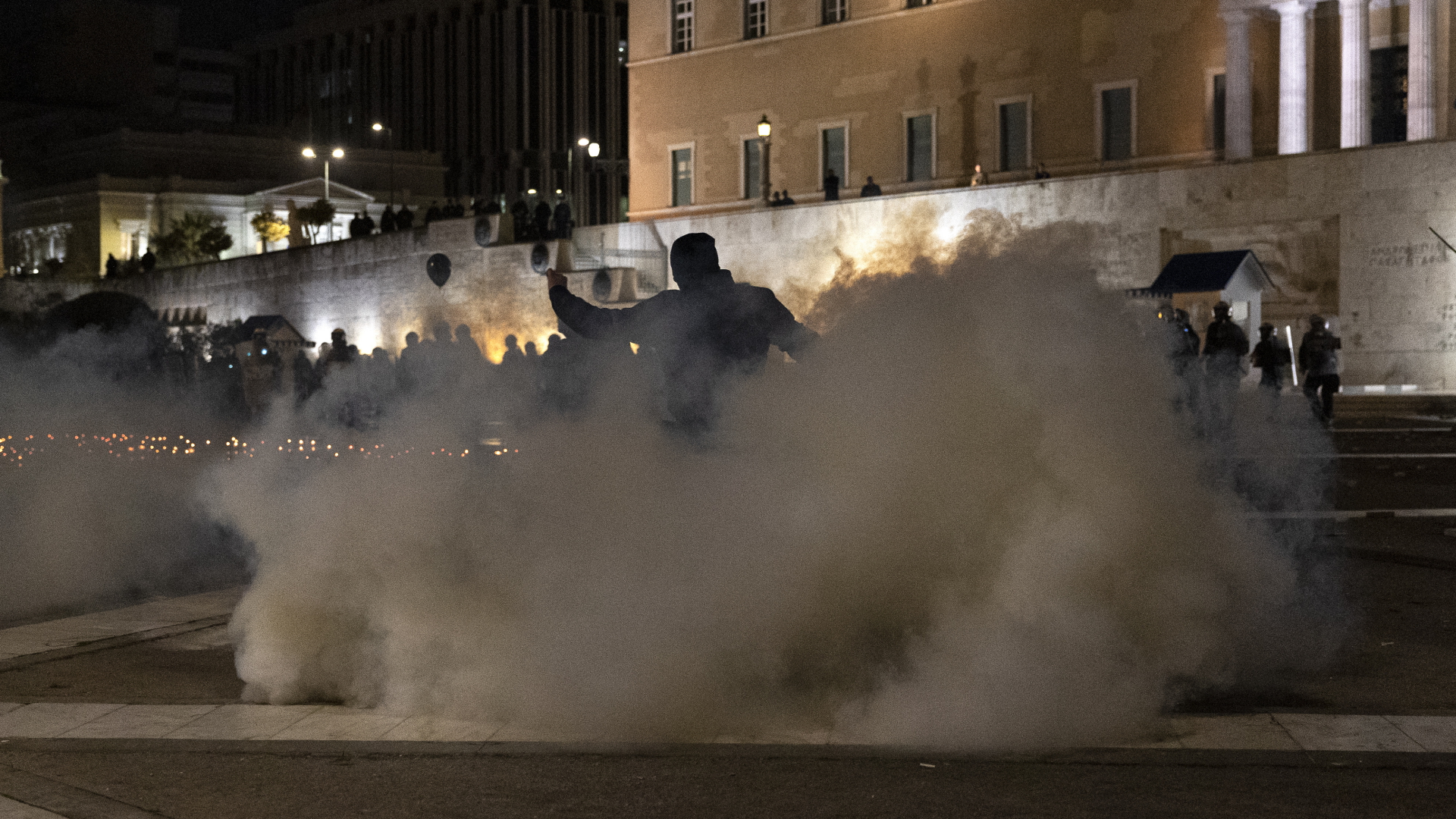 Ein Demonstrant flieht bei Zusammenstößen nach einer Demonstration mit der Polizei vor Tränengas. | dpa