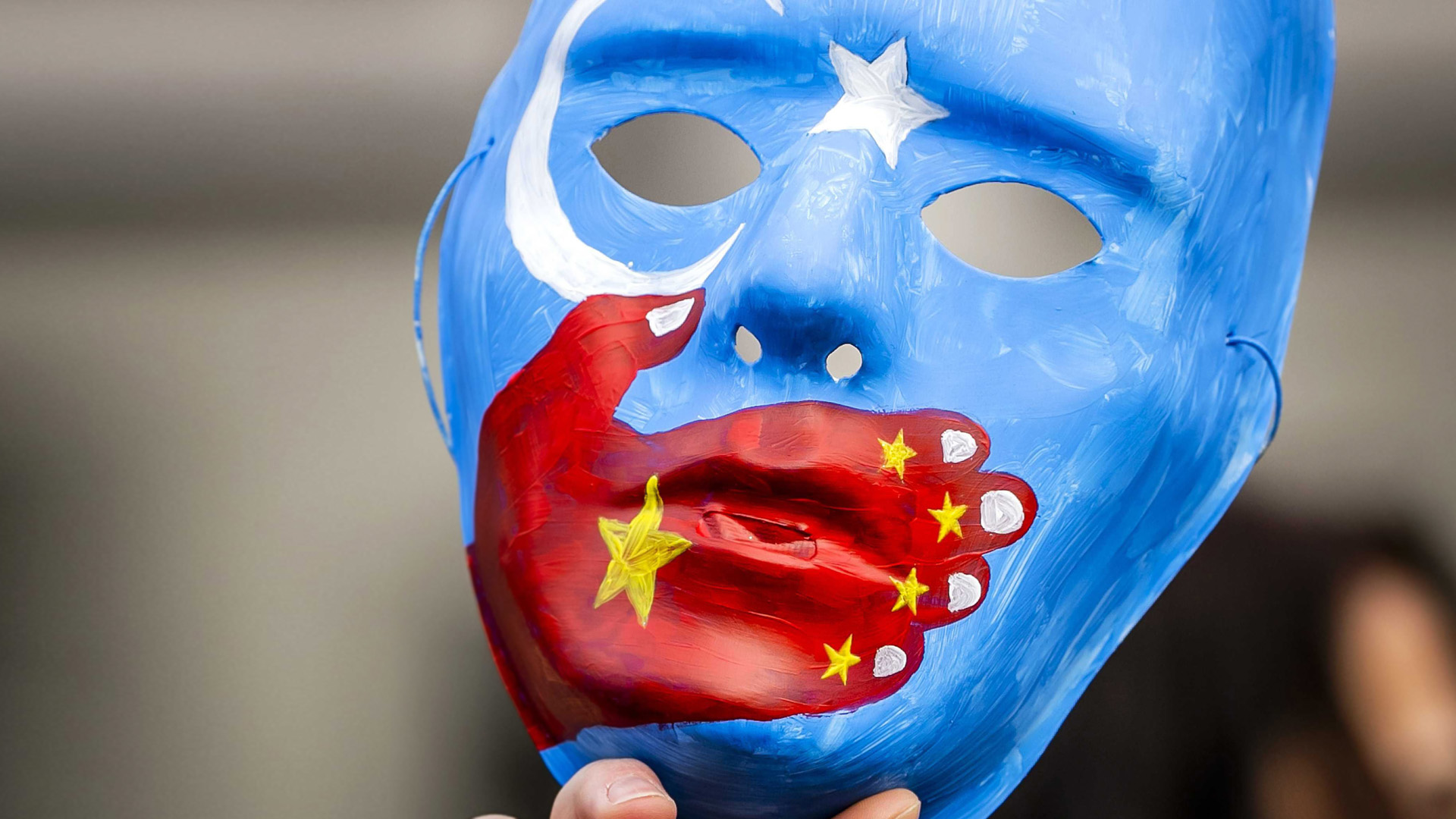 Maske bei einer Demonstration von Uiguren und Sympathisanten in Amsterdam