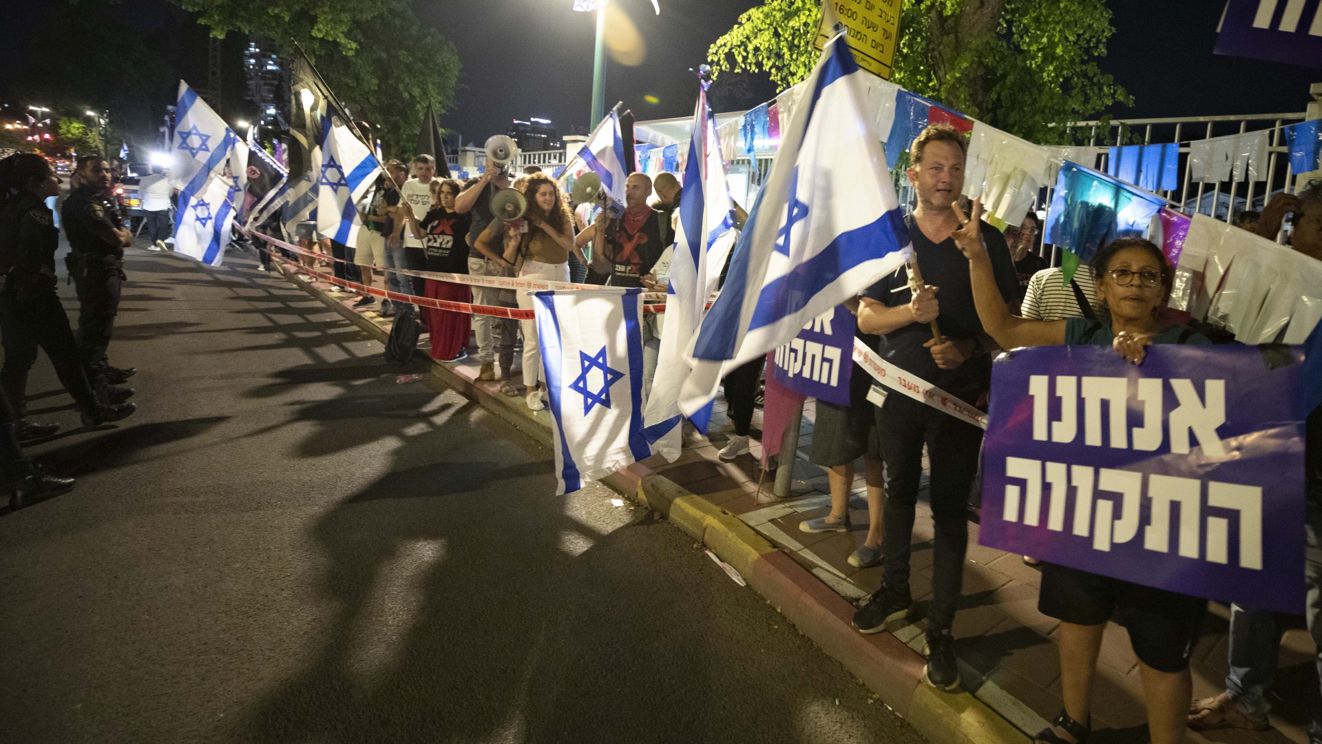 Israelische Demonstranten rufen Slogans und halten Fahnen während einer Demonstration für die Bildung einer neuen Regierung hoch (Archivbild). | dpa