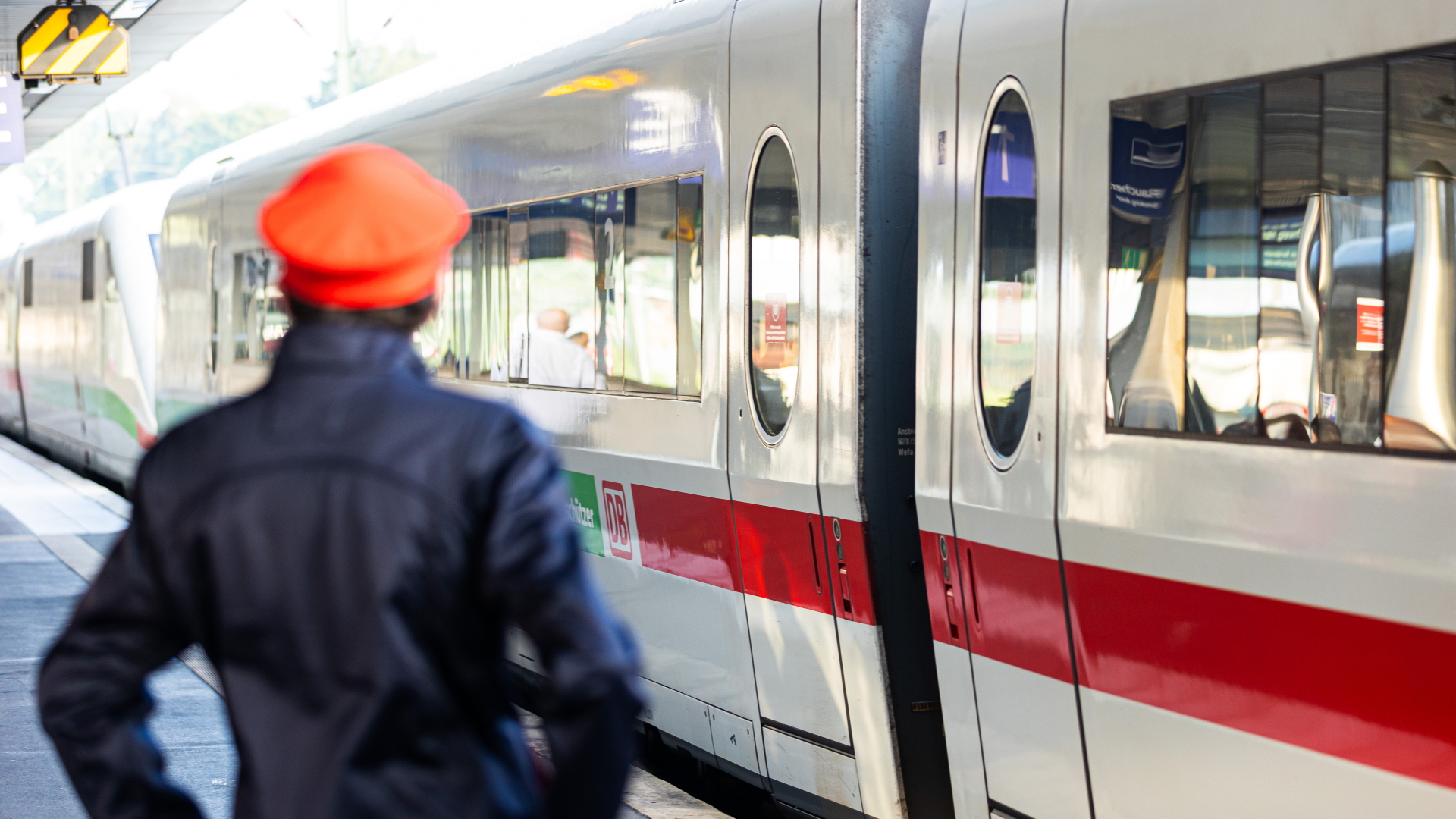 Ein Mitarbeiter der Deutschen Bahn steht neben einem ICE-Zug. | dpa