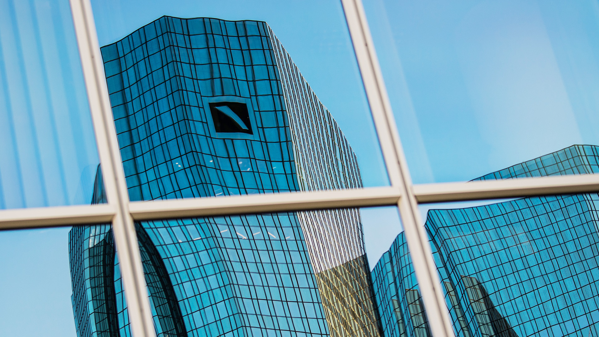 Das Logo der Deutschen Bank spiegelt sich in einer Hochhausfassade in Frankfurt am Main | dpa