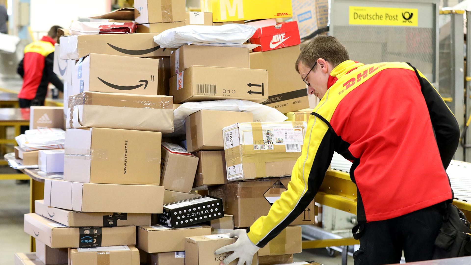 Ein DHL-Mitarbeiter sortiert Pakete in einer Zustellbasis der Deutschen Post.