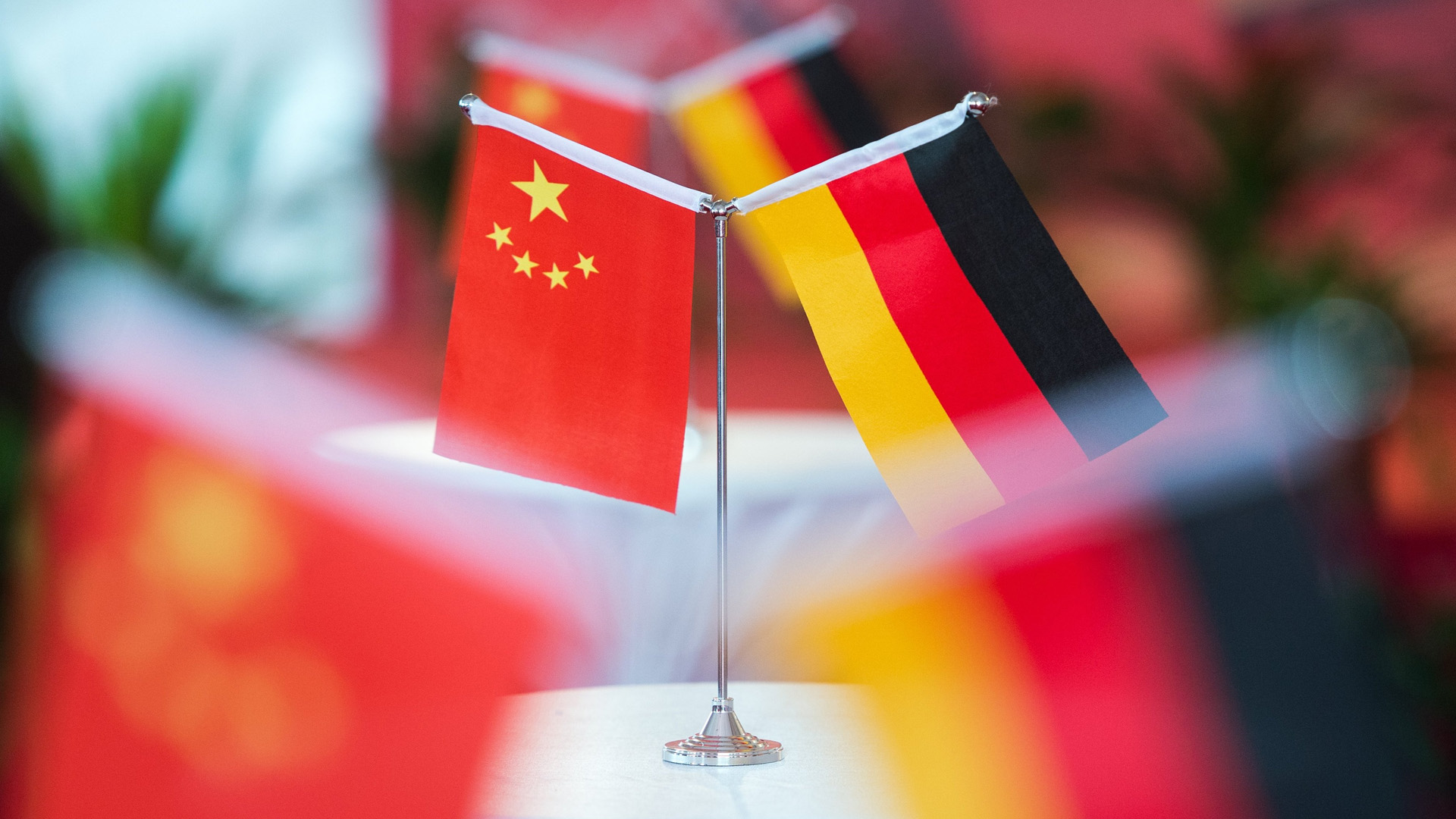 Kleine Flaggen Chinas und Deutschlands stehen auf einem Tisch