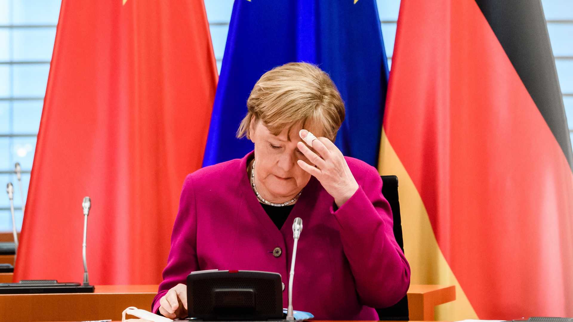 Bundeskanzlerin Angela Merkel berührt sich während digitaler Beratungen mit Chinas Ministerpräsidenten Li im April 2021 an der Stirn.