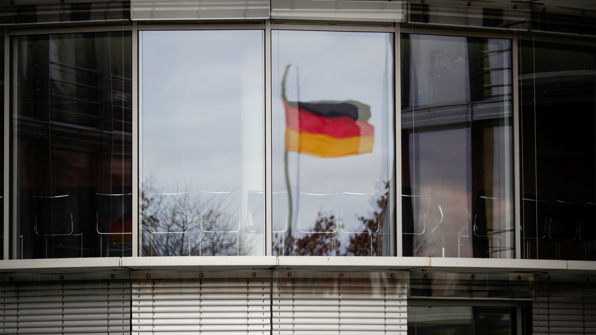 Die deutsche Fahne spiegelt sich in einem Fenster des Paul-Löbe-Hauses. | REUTERS