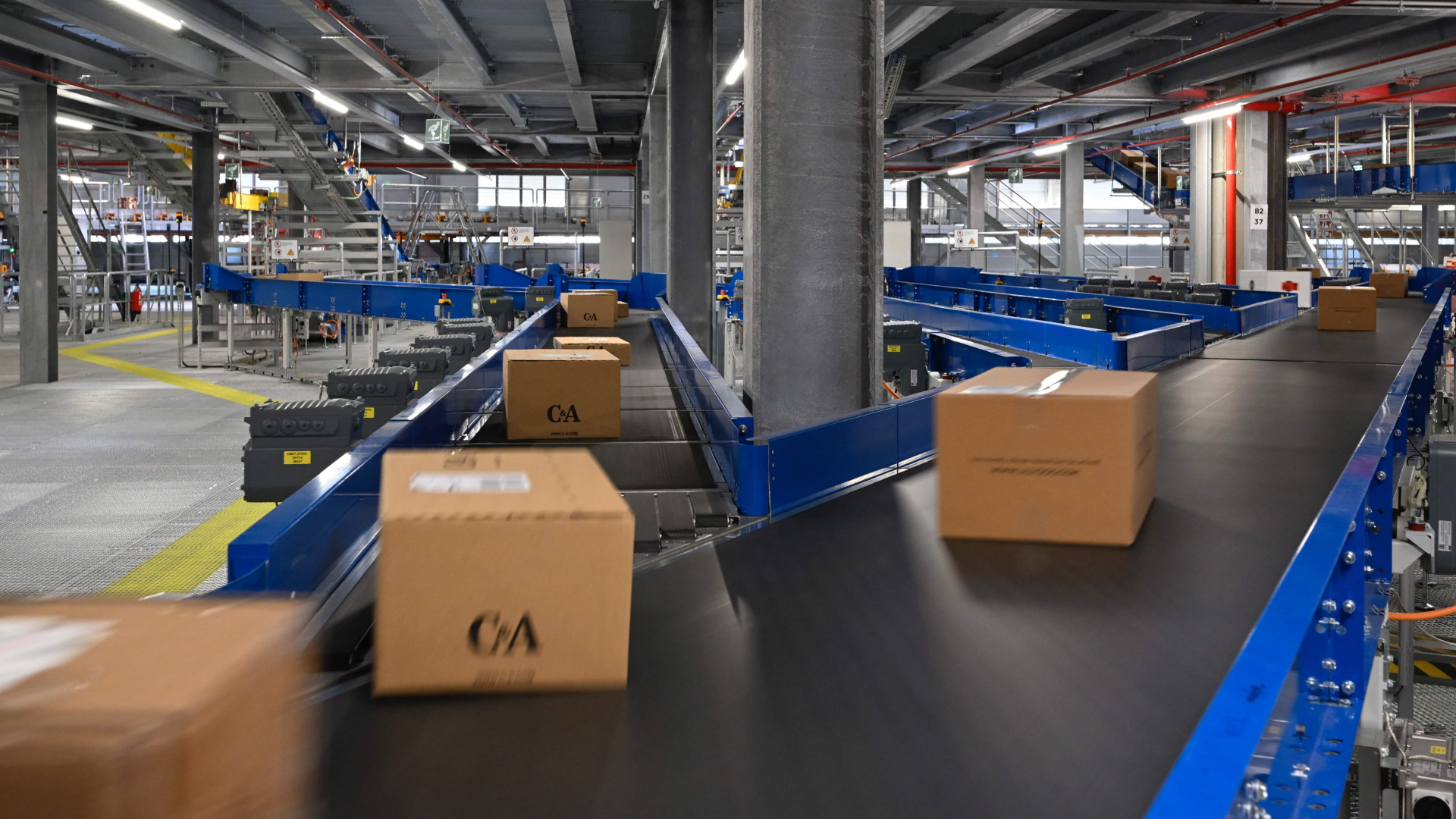 Pakete laufen in einem Sortierzentrum von DHL über Förderbänder | AFP
