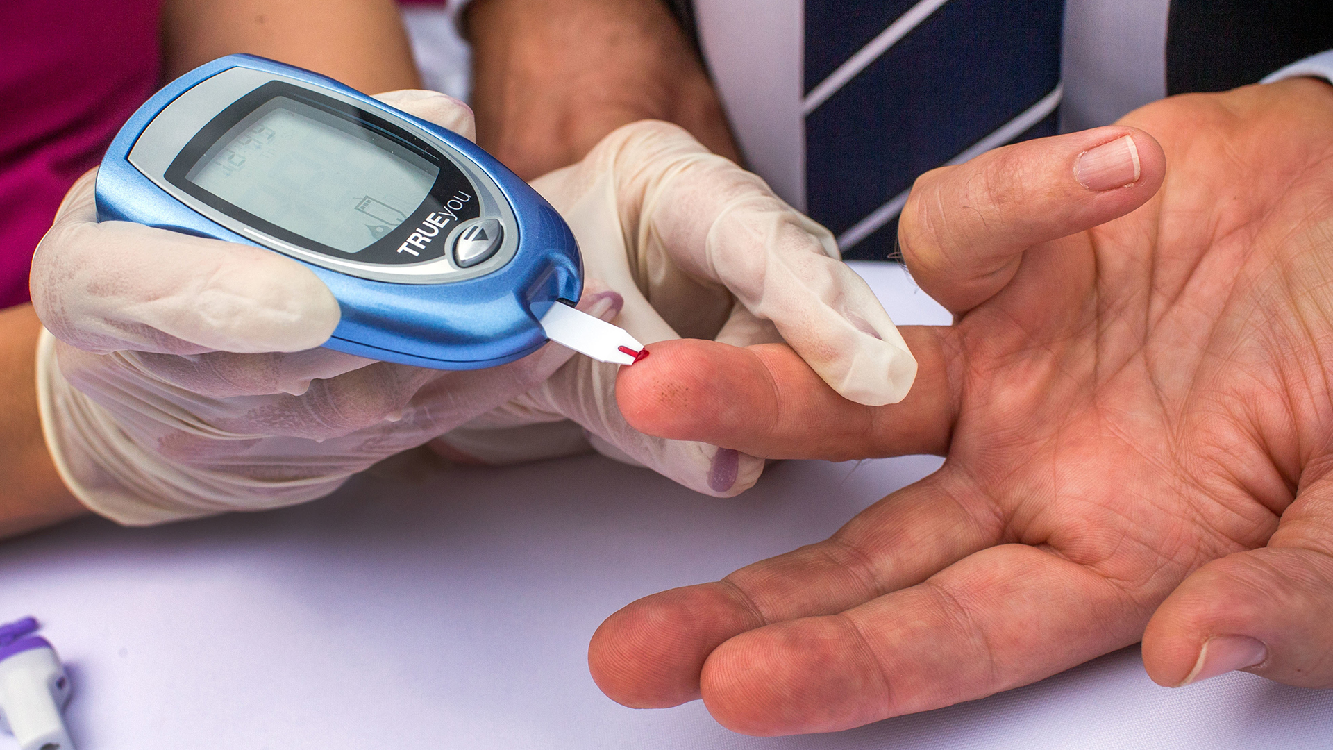 Ein Mann lässt sich von einer Diabetesberaterin eine Blutprobe für einen Blutzuckertest nehmen. | picture alliance/dpa