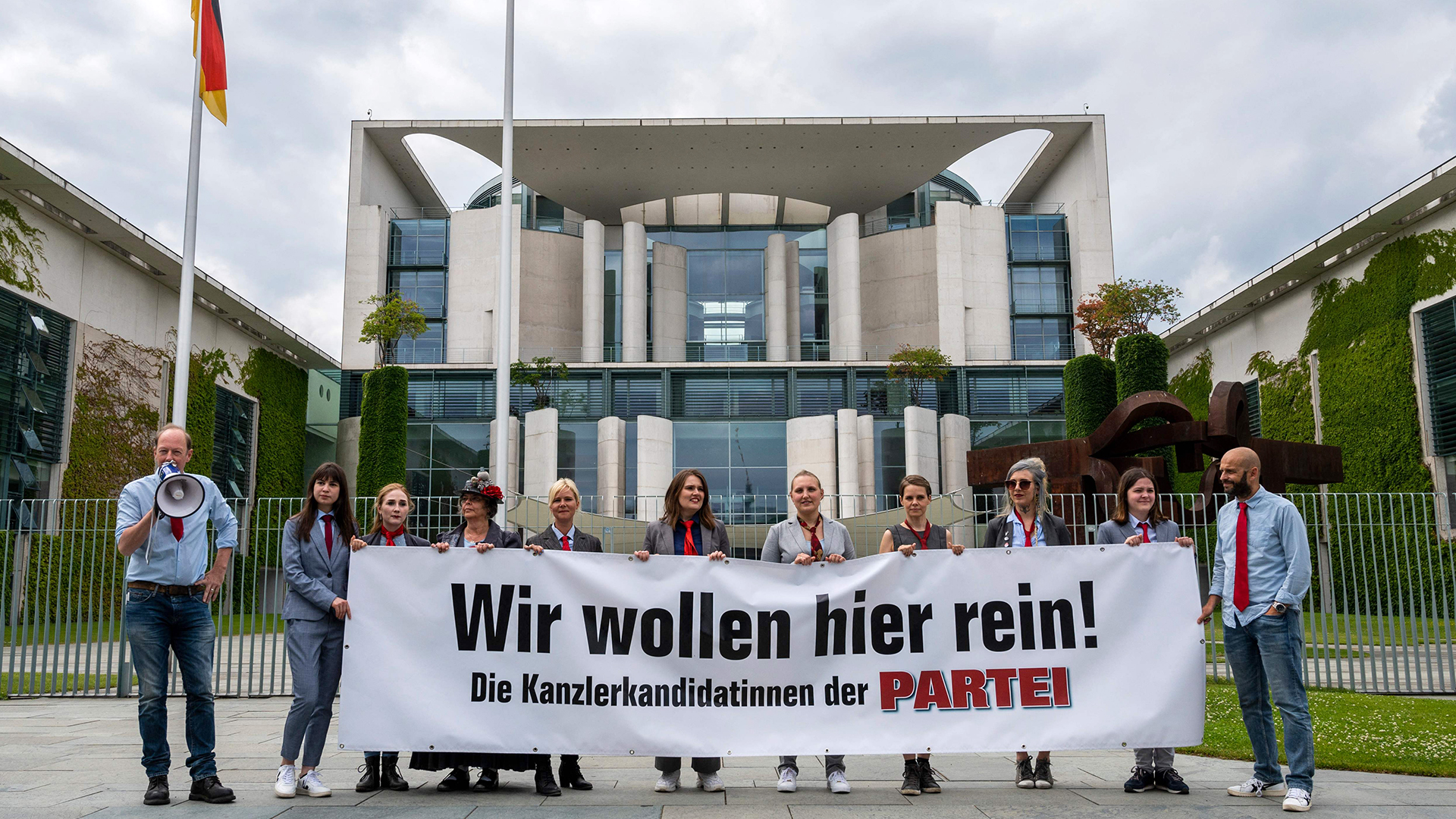 Mitglieder der "Partei" stehen mit einem Transparent mit der Aufschrift "Wir wollen hier rein!" vor dem Bundeskanzleramt.