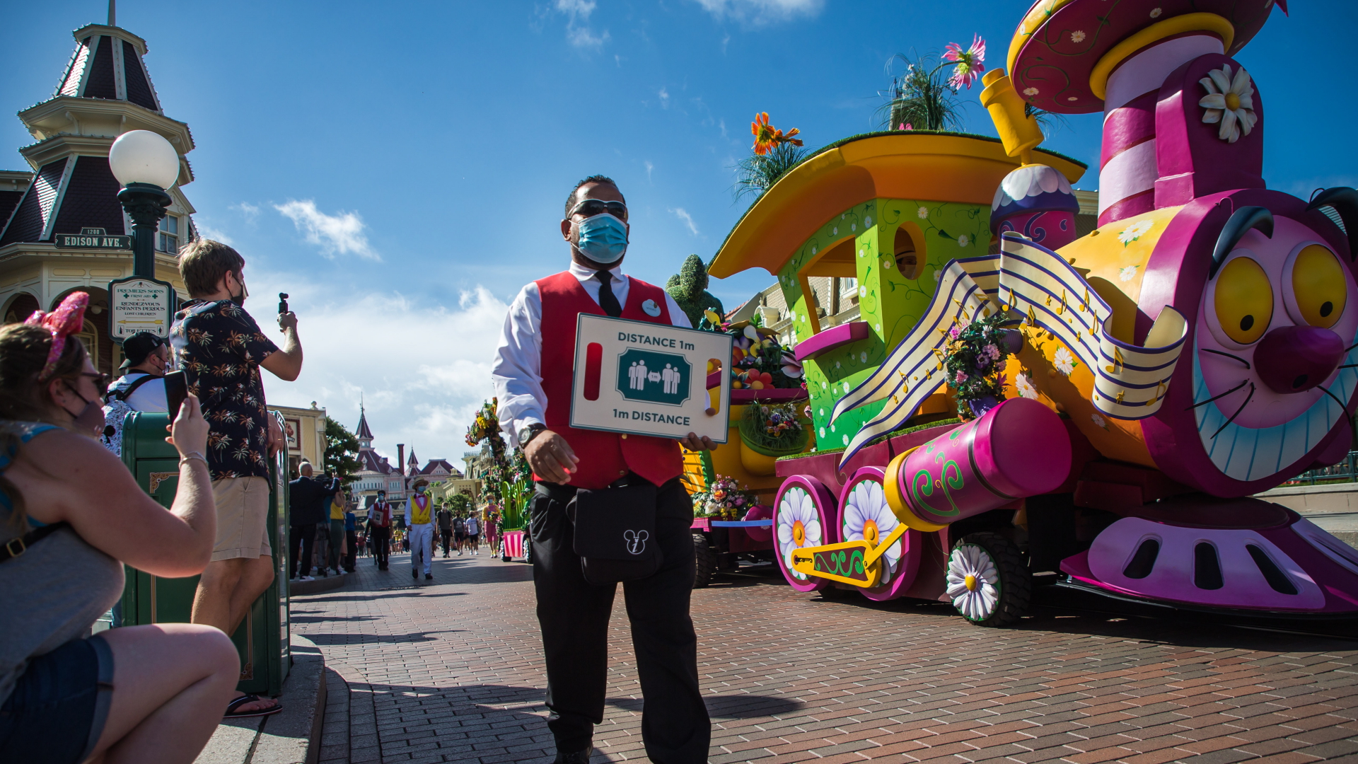 Ein Mitarbeiter im Disneyland Paris weist auf die Corona-Regeln hin | EPA
