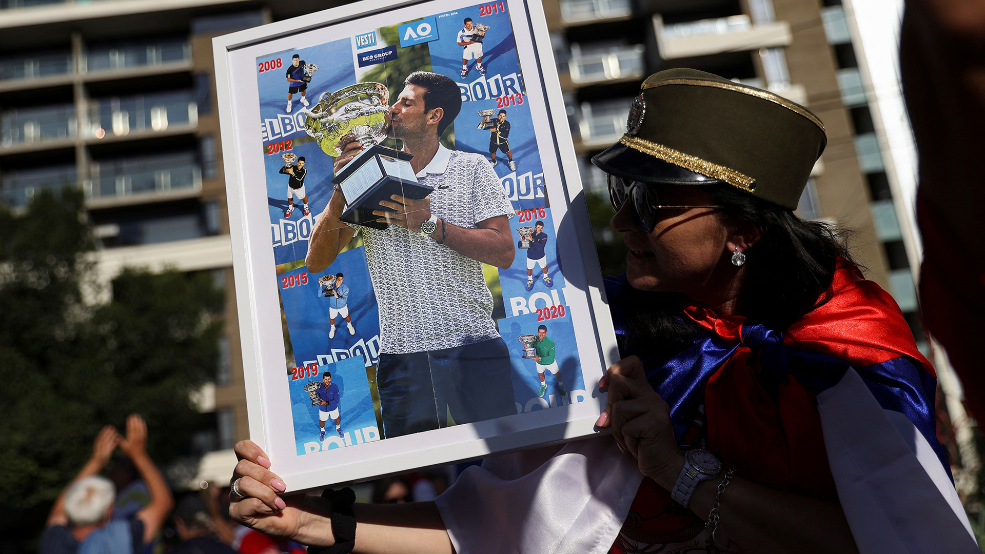 Eine Frau hält ein Bild von Novak Djokovic in der Hand. | REUTERS