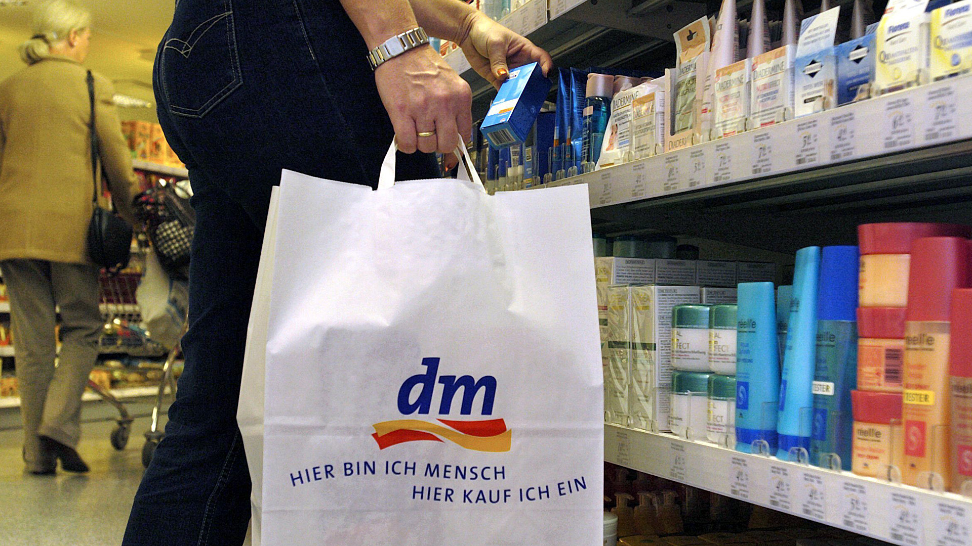 Eine Frau mit dm-Tüte in einem dm-Markt | picture alliance / dpa