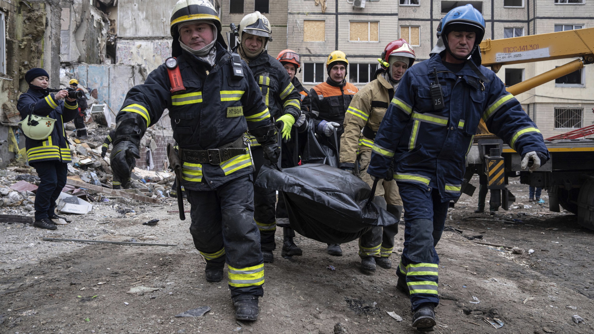 Rettungskräfte tragen in einen Sach gehüllten Leichnam eines Mannes, der beim Angriff auf ein Hochhaus in Dnipro getötet wurde | AP