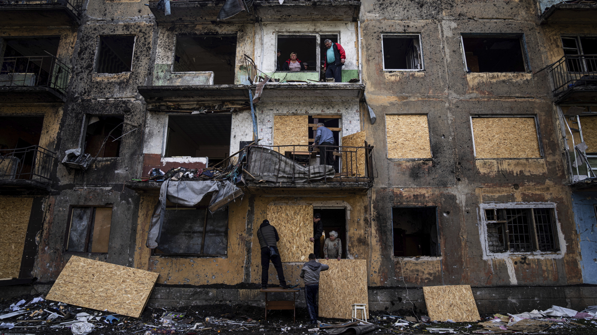 Anwohner schließen die Fenster eines Wohnhauses mit Sperrholz in Dobropillja in der Region Donezk in der Ostukraine.  | dpa