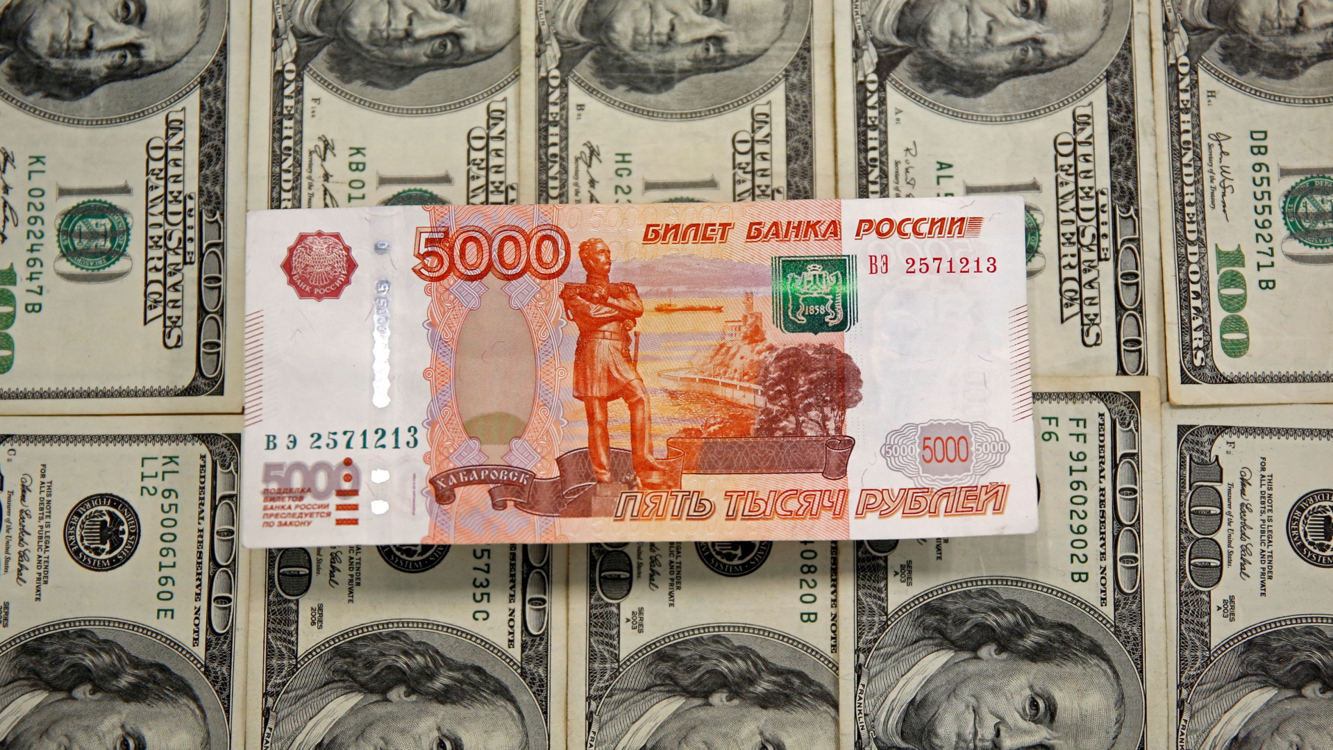 Ein Rubelschein und mehrere Dollarnoten | REUTERS