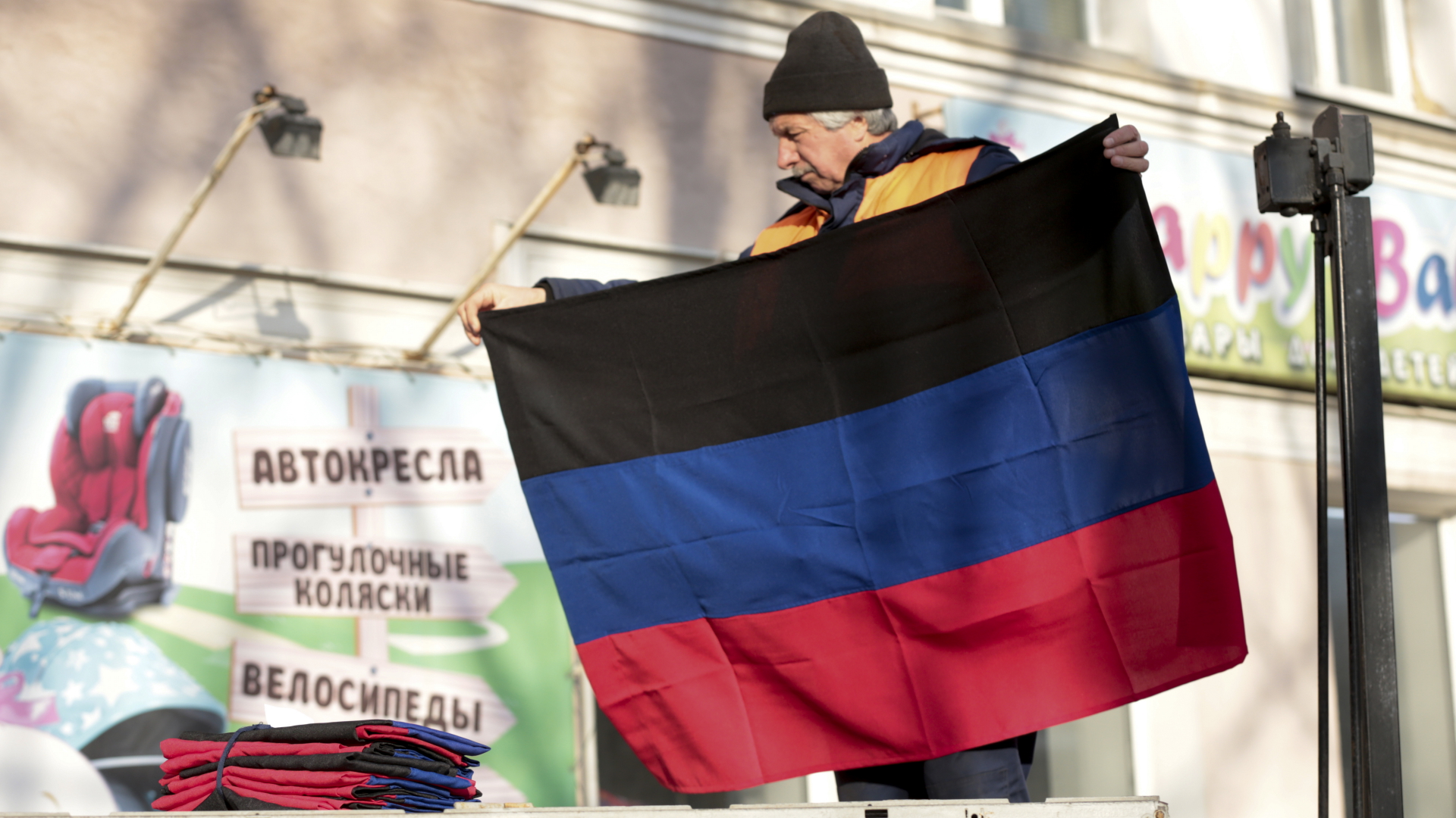 Ein Arbeiter hängt in Donezk die Flagge der international nicht anerkannten Volksrepublik Donezk auf. | dpa