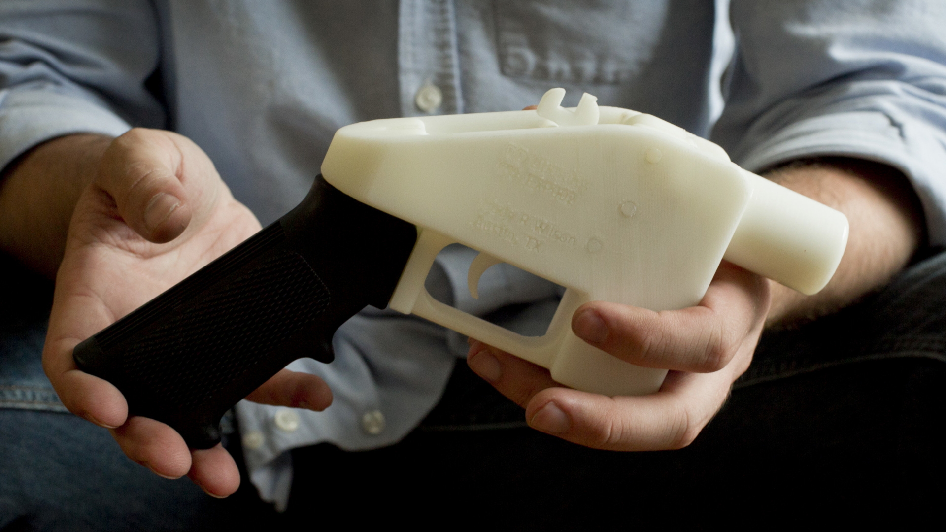 Ein Mann hält eine Waffe in der Hand, die per 3D-Druck entstanden ist.